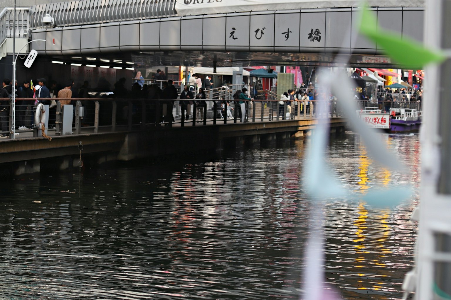 Personas reunidas bajo un puente mirando el río