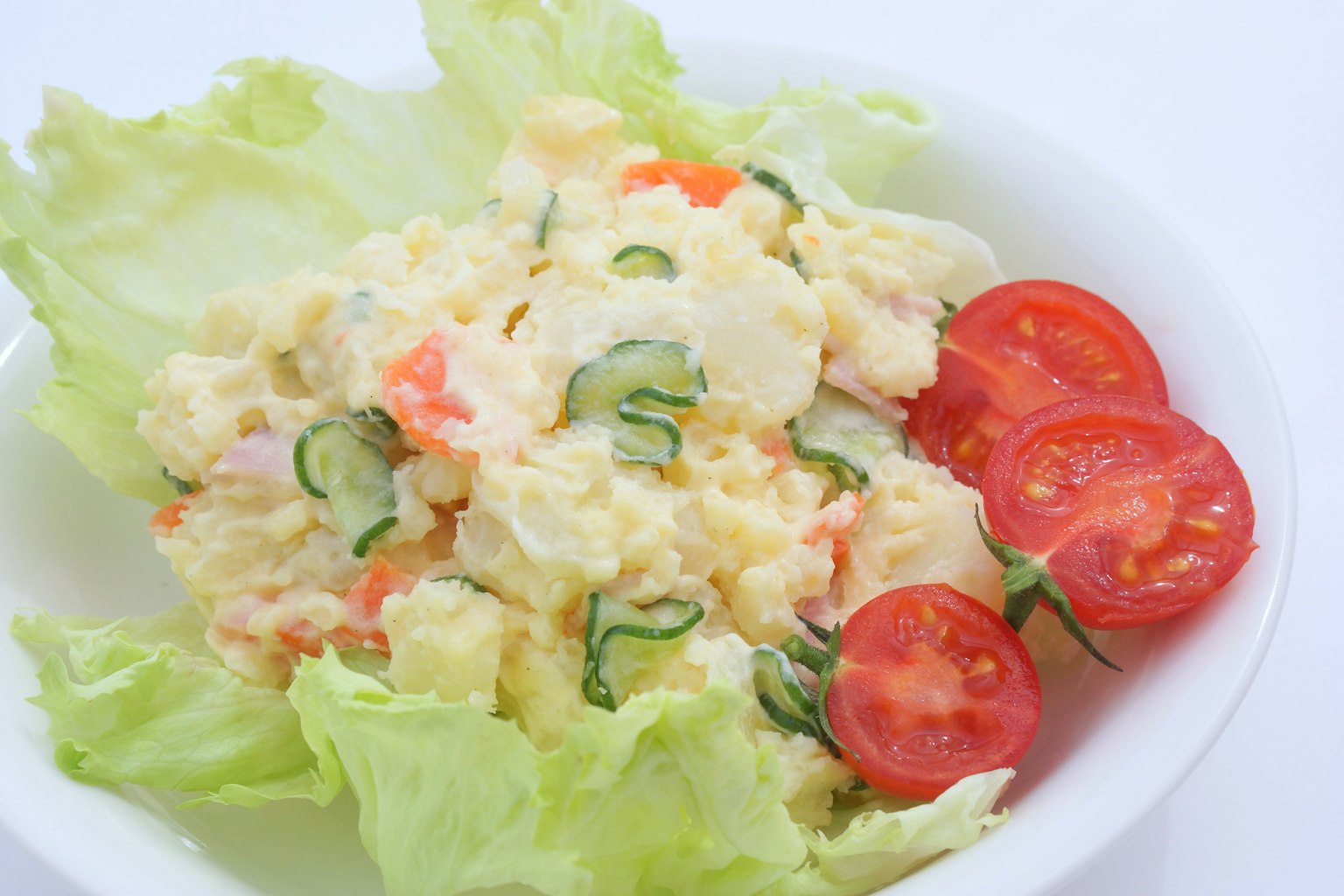 Salade de pommes de terre crémeuse servie avec de la laitue et des tomates cerises