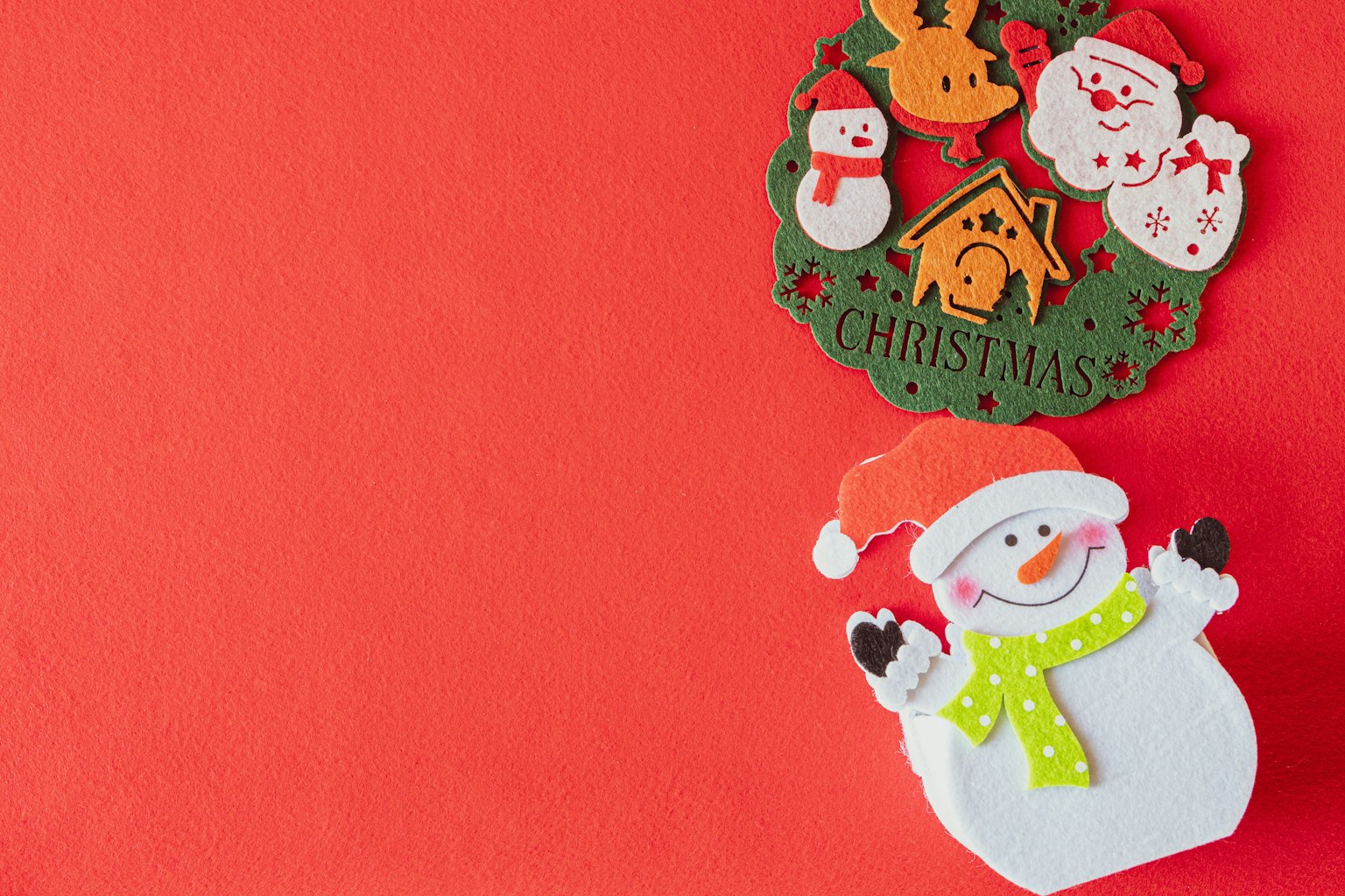 Decorazioni natalizie con un pupazzo di neve e varie figure festive su uno sfondo rosso