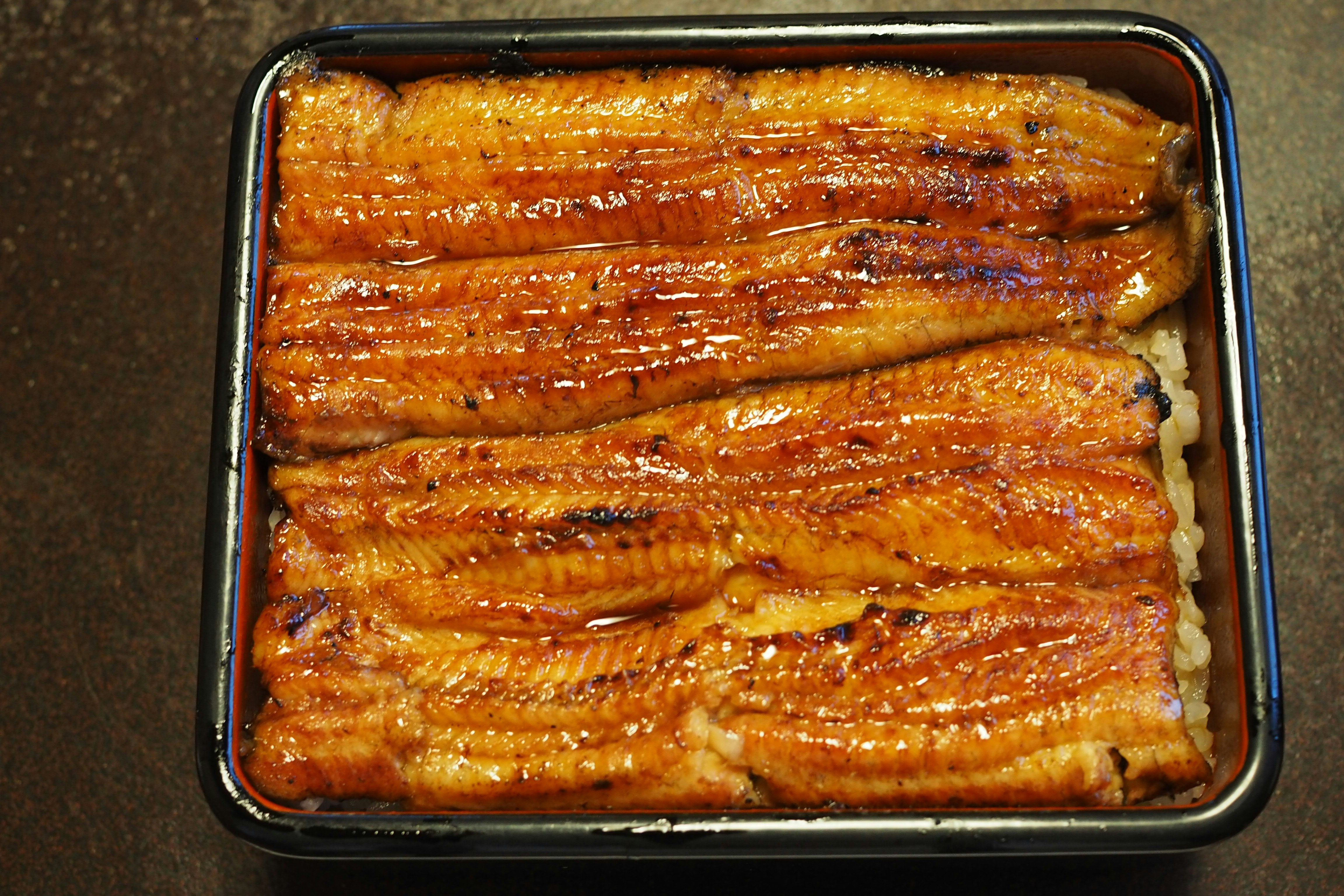 長方形の弁当箱に入った焼きうなぎ