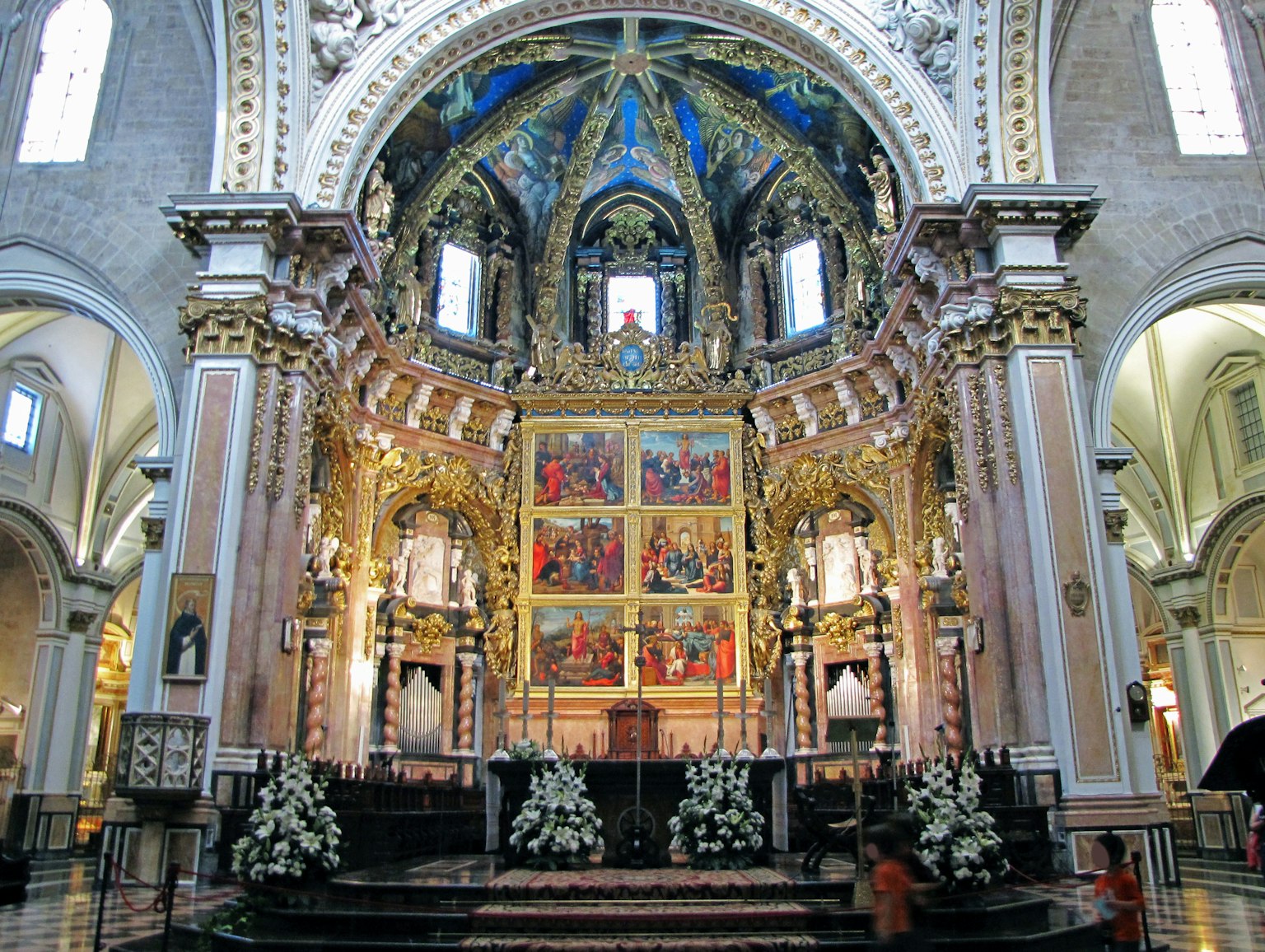 Intérieur d'une belle église avec un autel décoratif et un plafond bleu vibrant, ornements dorés et peintures