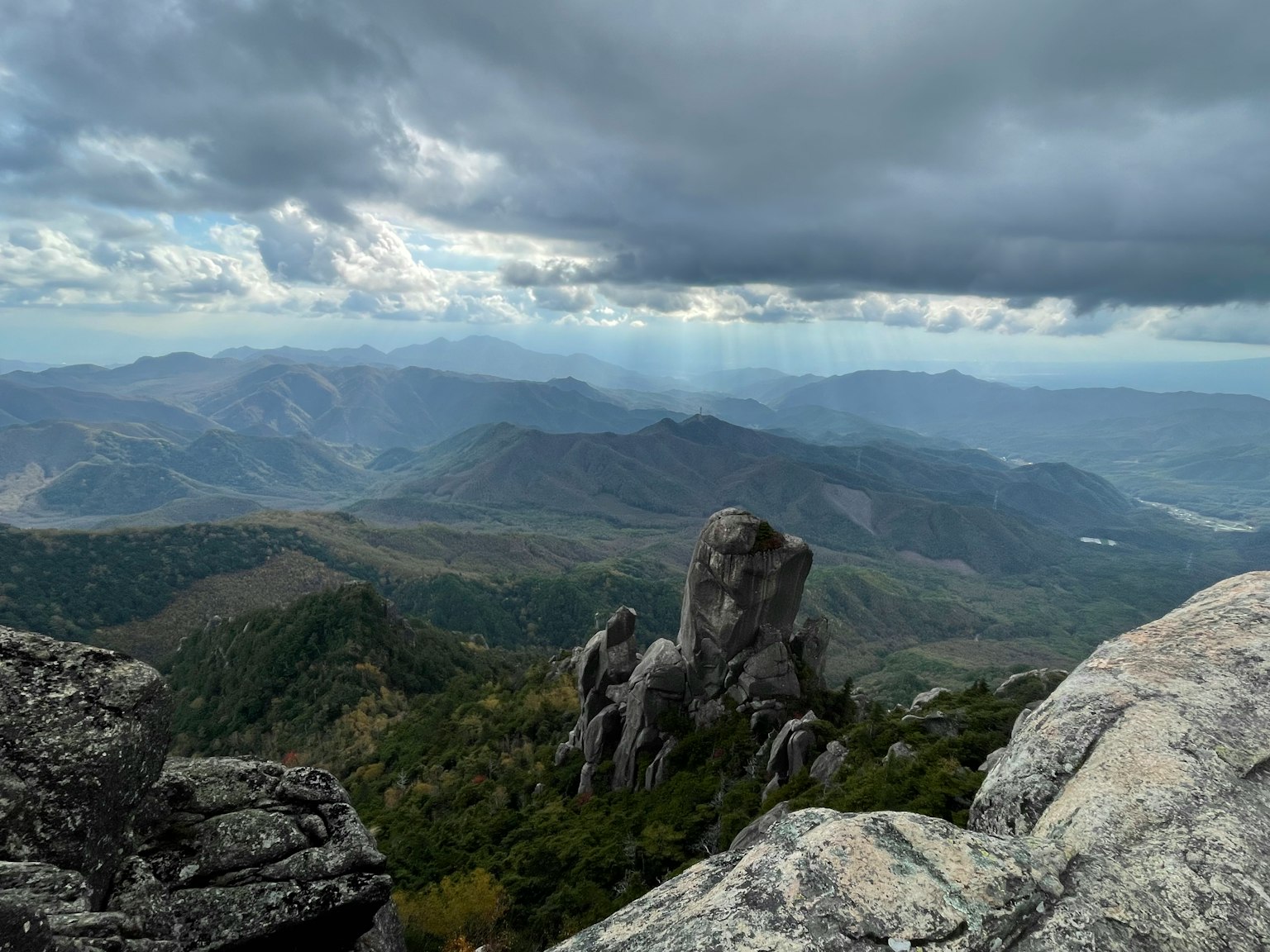 Foto lanskap dengan gunung dan awan batu tajam dan bukit hijau