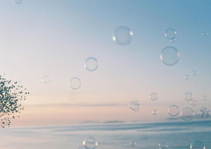 海辺に浮かぶ泡のような水滴と淡い空の風景