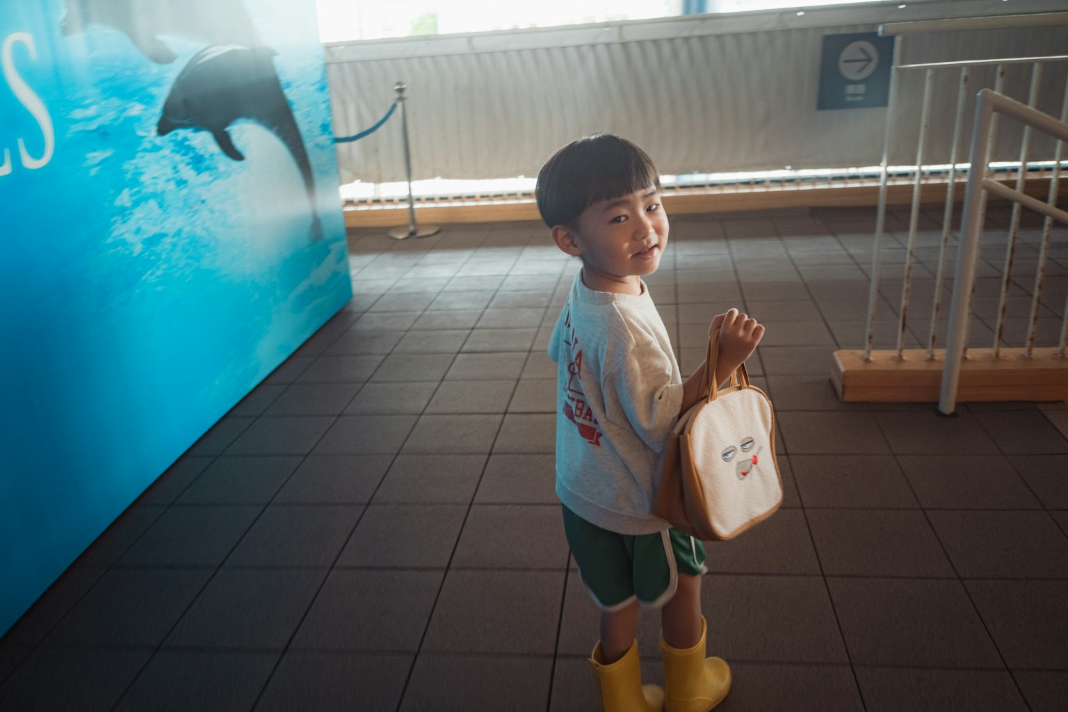 Trẻ em cầm túi đứng trước bức tường màu xanh