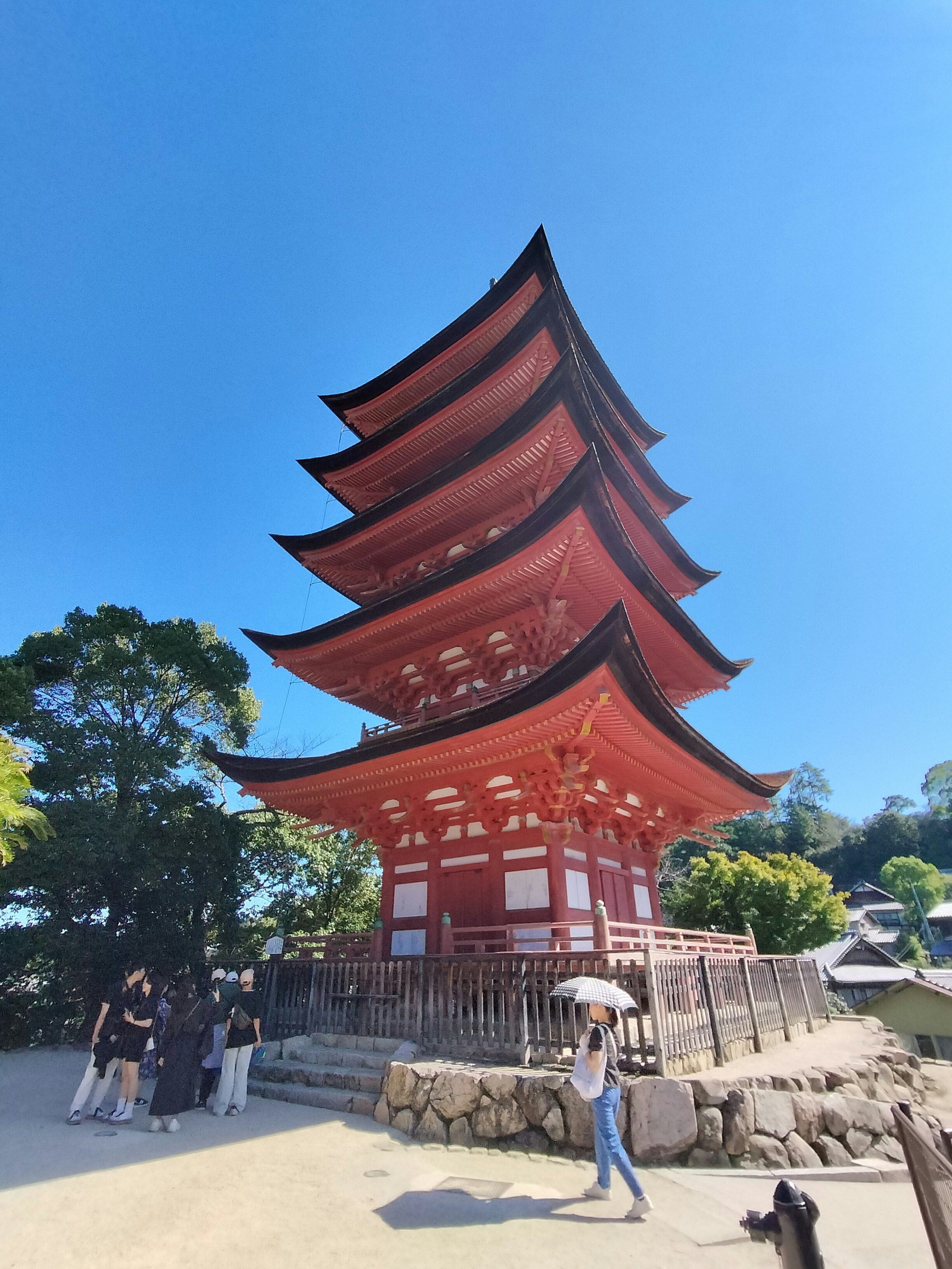 厳島神社の朱塗りの五重塔と参道の風景