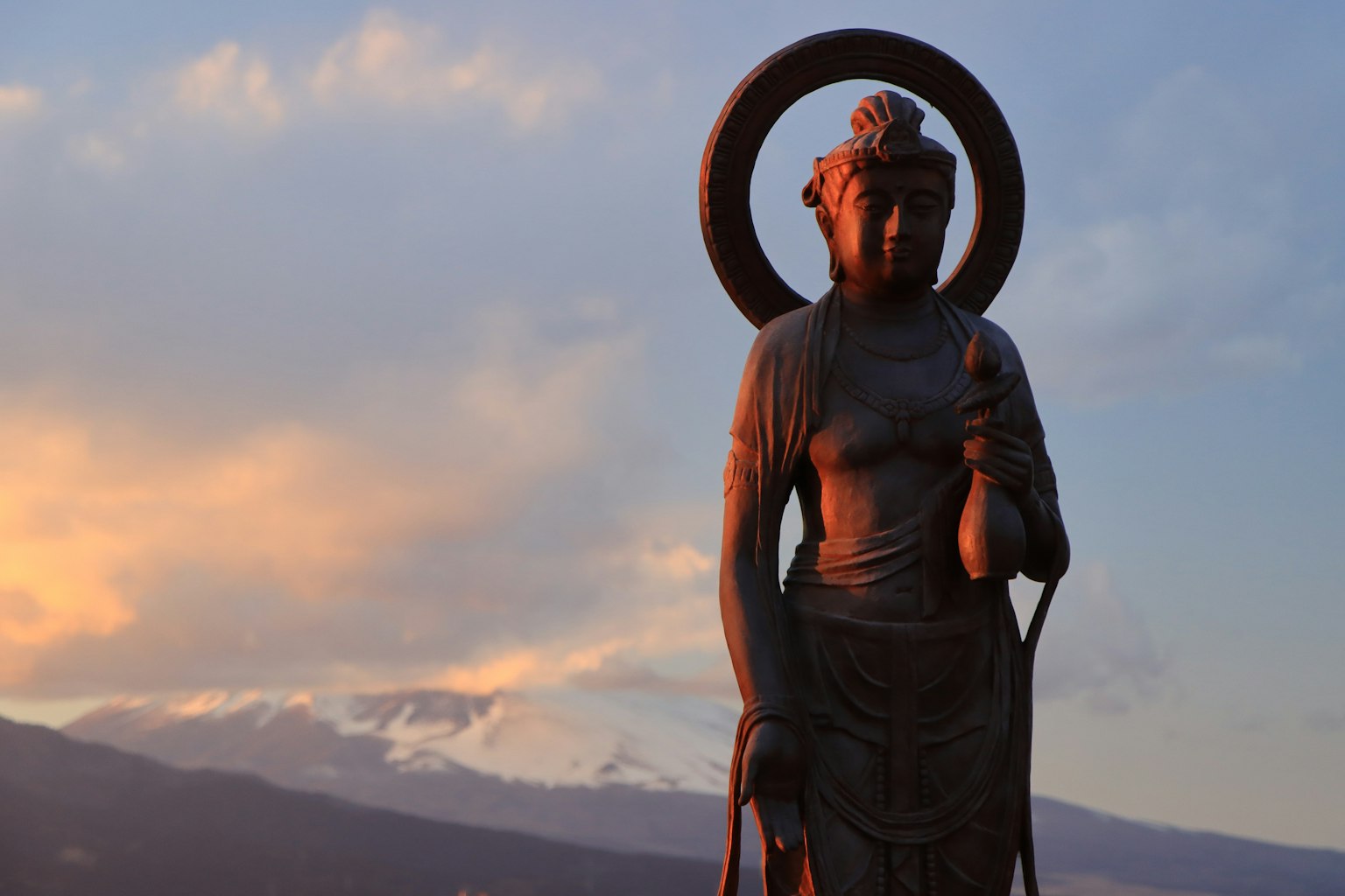 Kannon-Statue, die vor einem schönen Sonnenuntergang steht