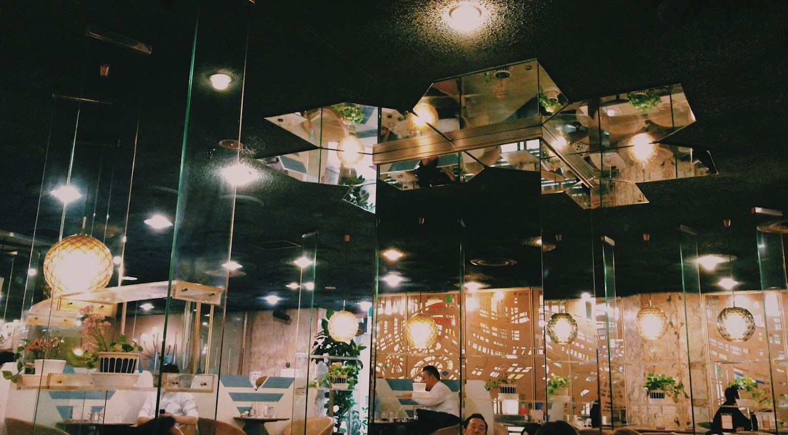 Interno di un ristorante moderno con soffitto a specchio e illuminazione ambientale