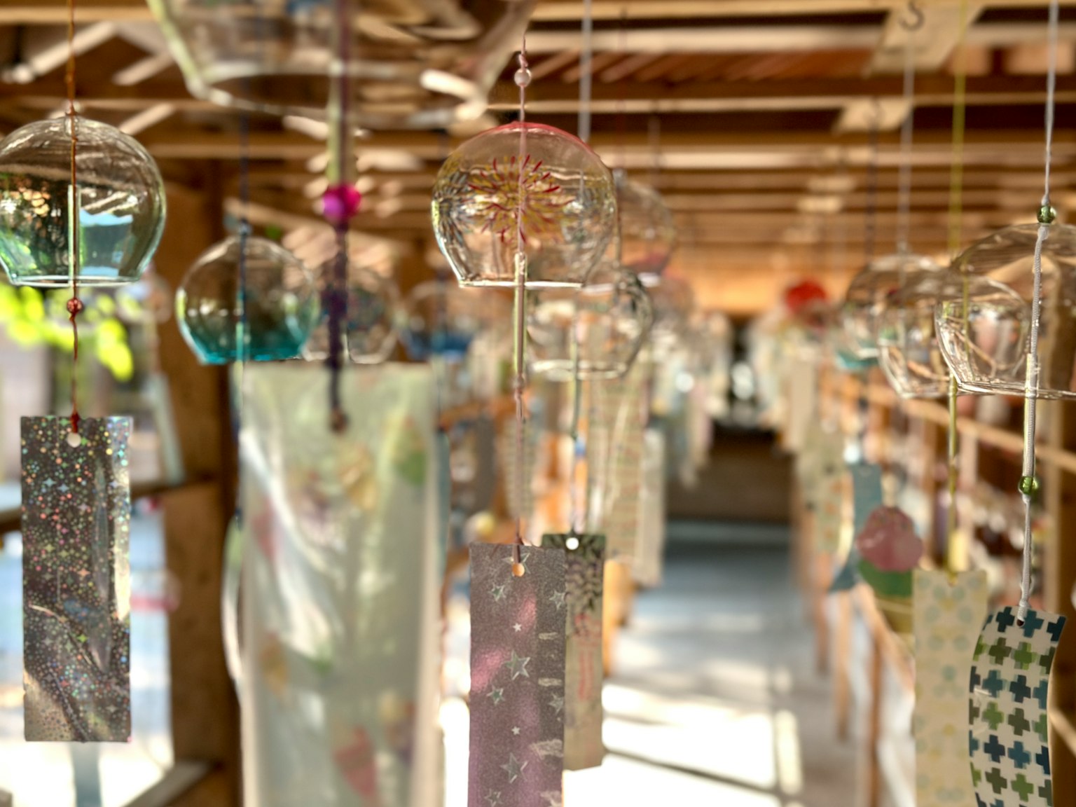 Ein traditioneller japanischer Raum mit hängenden, transparenten Windspielen verschiedene Designstreifen, die schwingen