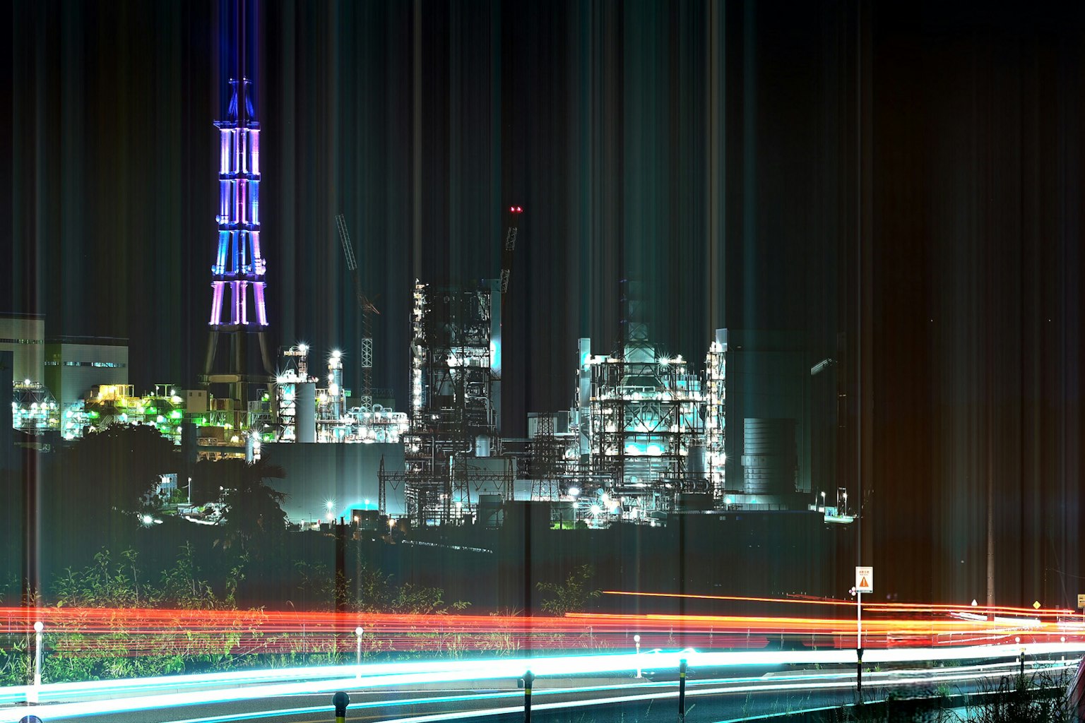 Night view of a factory skyline with Tokyo Tower illuminated