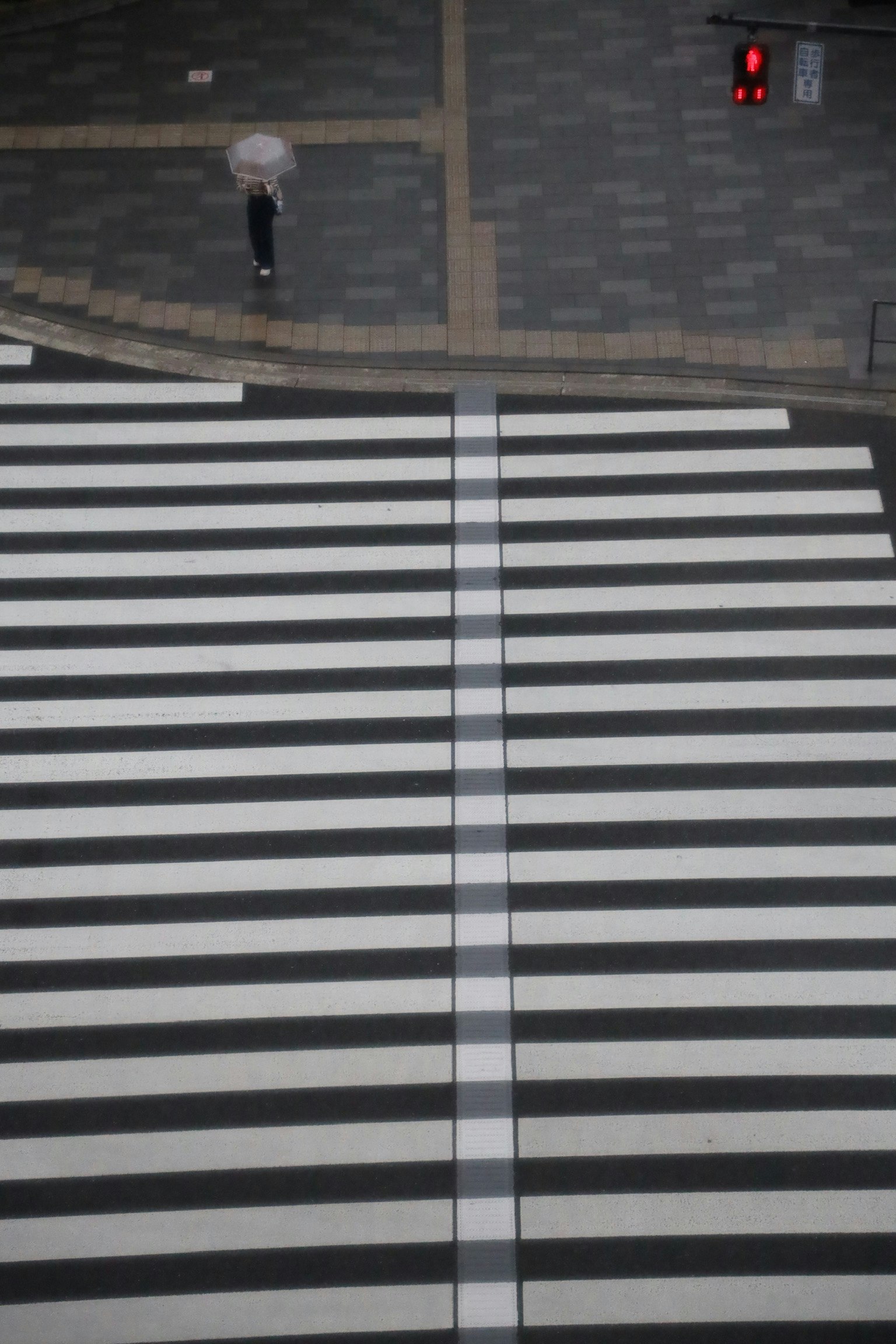 白と黒のストライプの横断歩道と赤信号の交差点