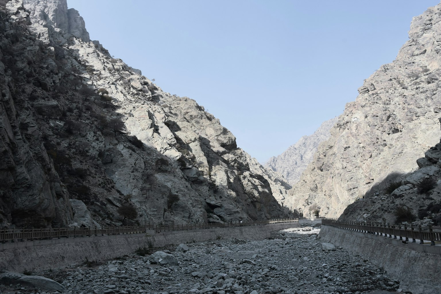 Dry valley landscape with rocks and mountains flanking a narrow path