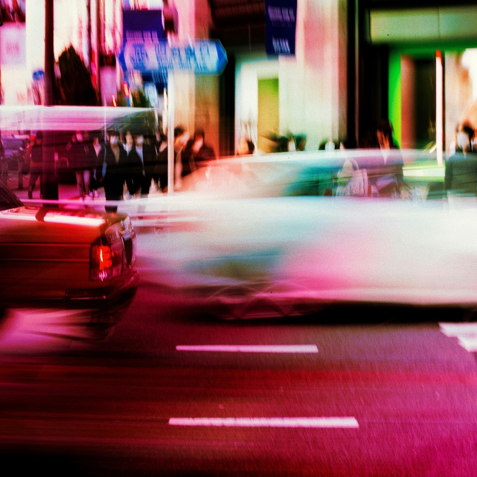 五彩繽紛的霓虹燈照亮城市街道，汽車快速駛過