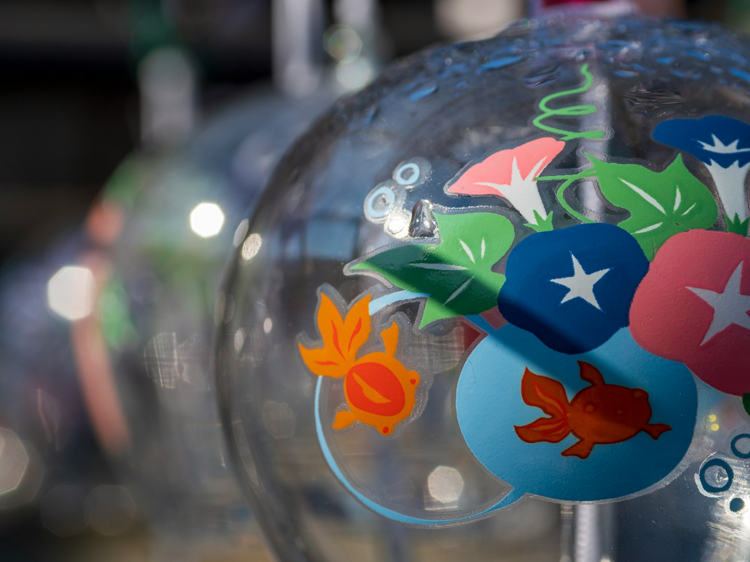 Ornement en verre transparent avec des motifs colorés de fleurs et de poissons