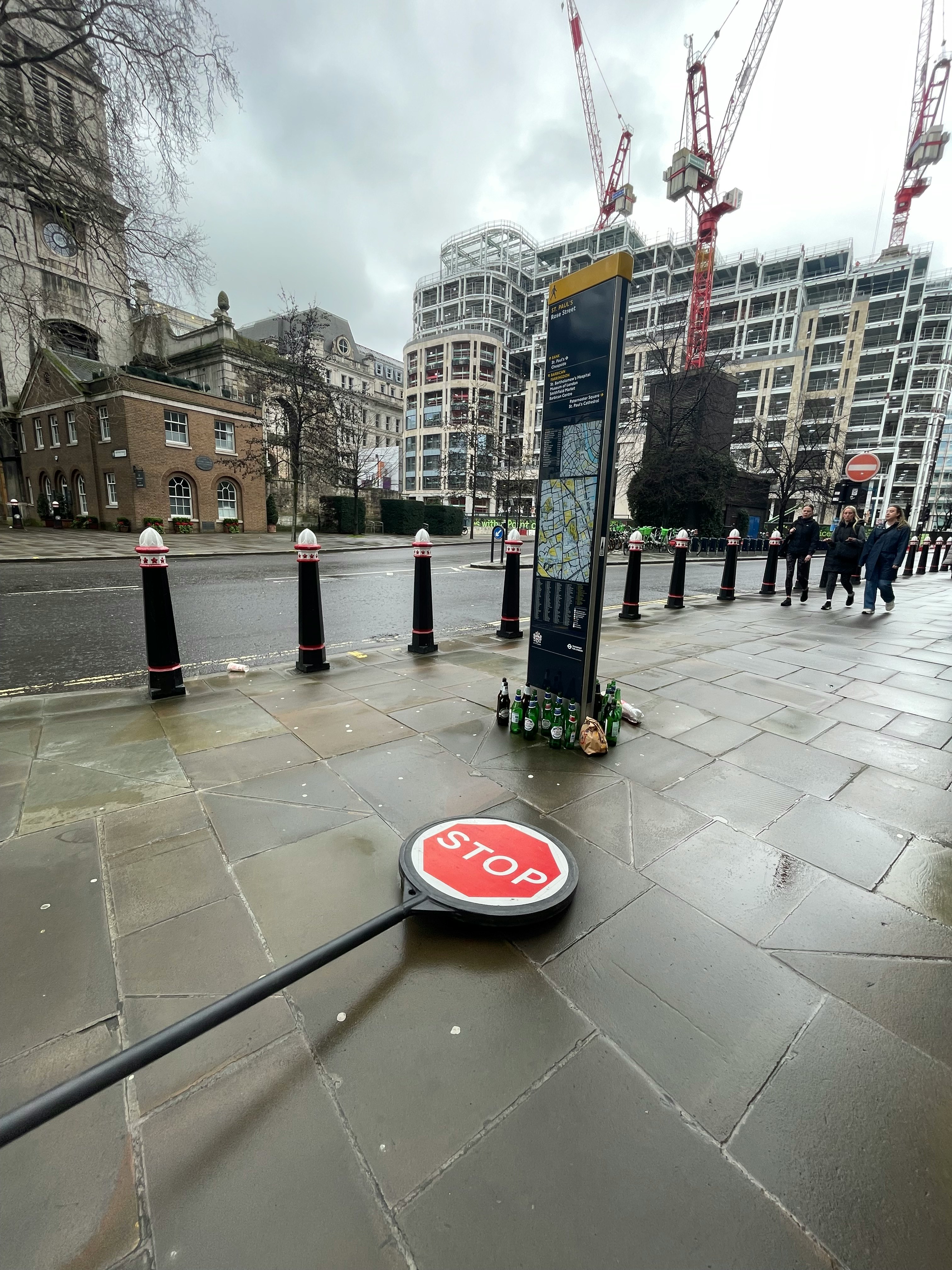 ロンドンの石造りの広場でSTOP看板の前に工事中の高層ビル群
