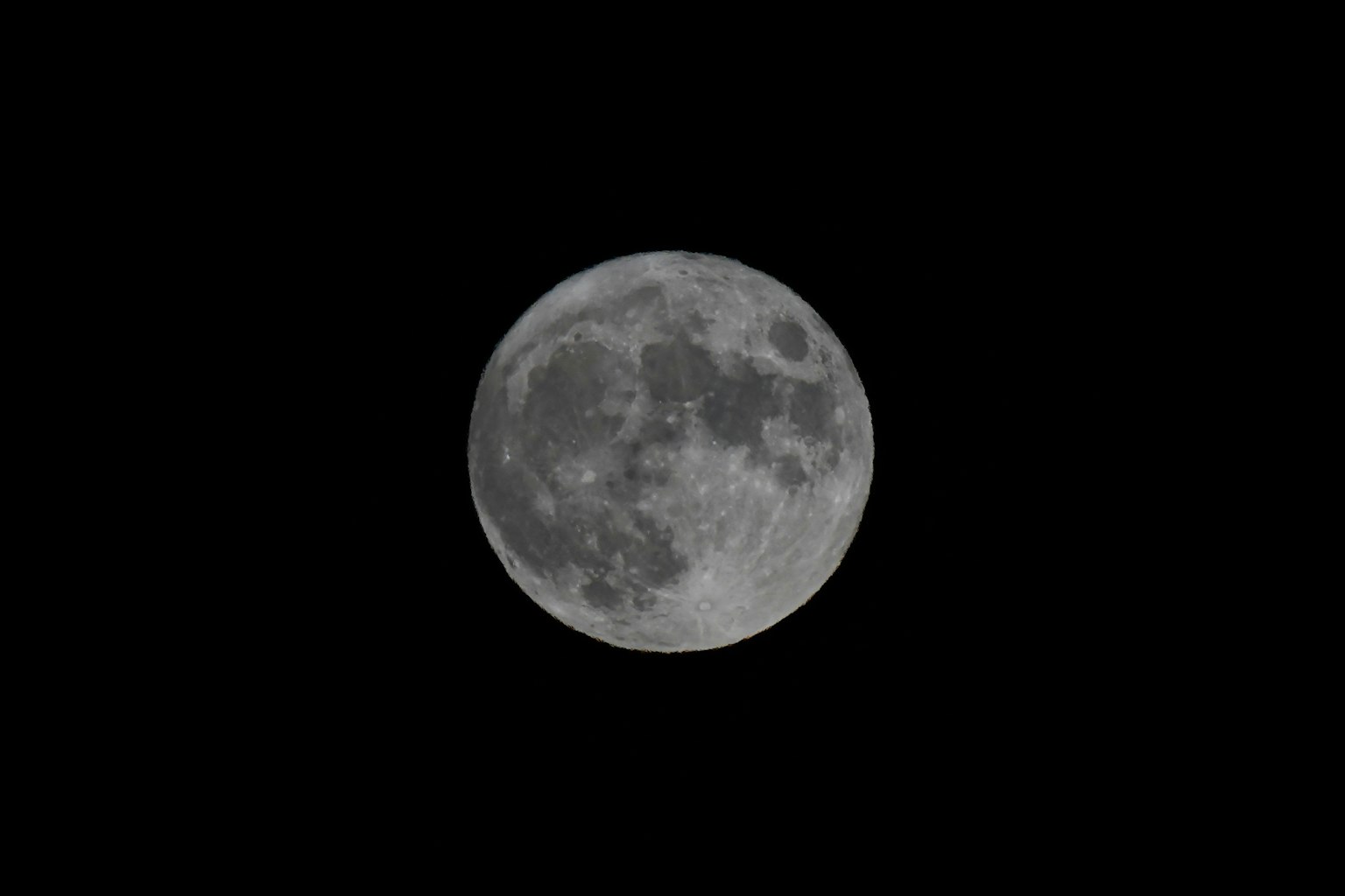 Una hermosa luna llena flotando sobre un fondo negro