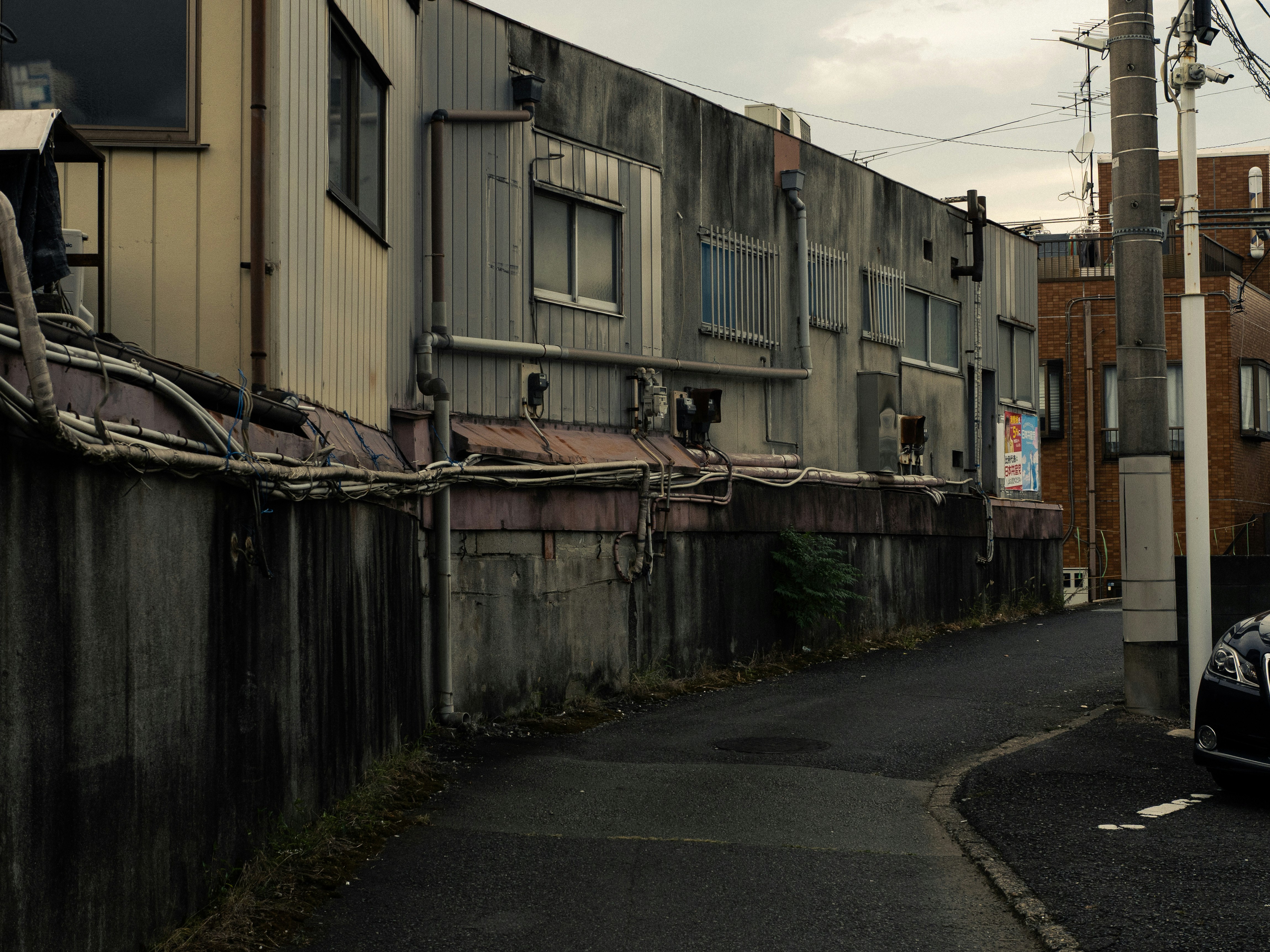 都内の横道に続く路地と電線のある街並み