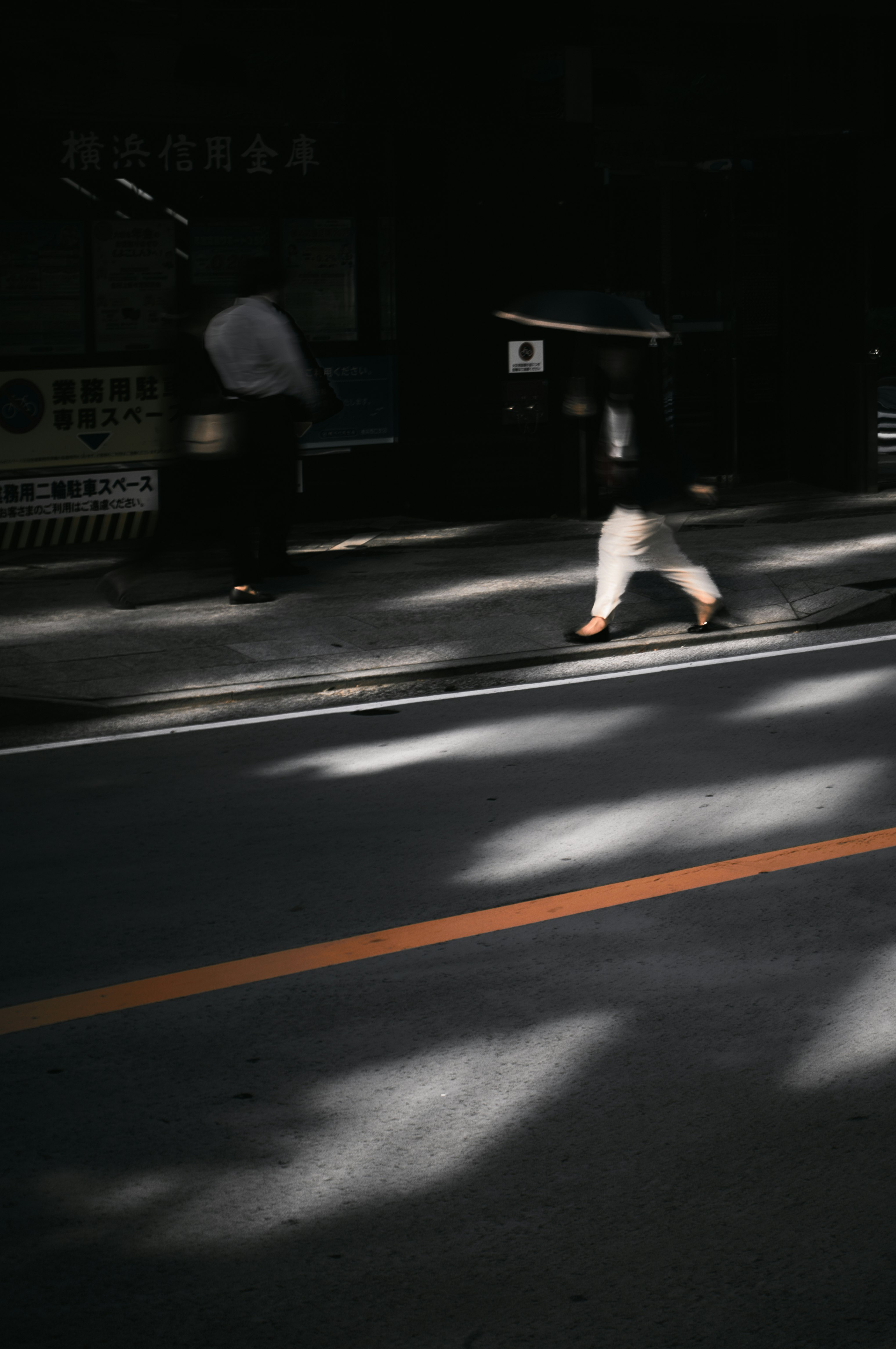 silhouette of a person running across a crosswalk at night
