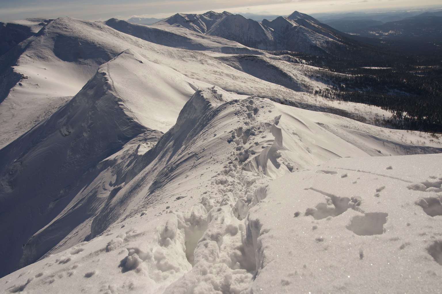 Schneebedeckte Berggipfellandschaft mit sichtbaren Fußabdrücken
