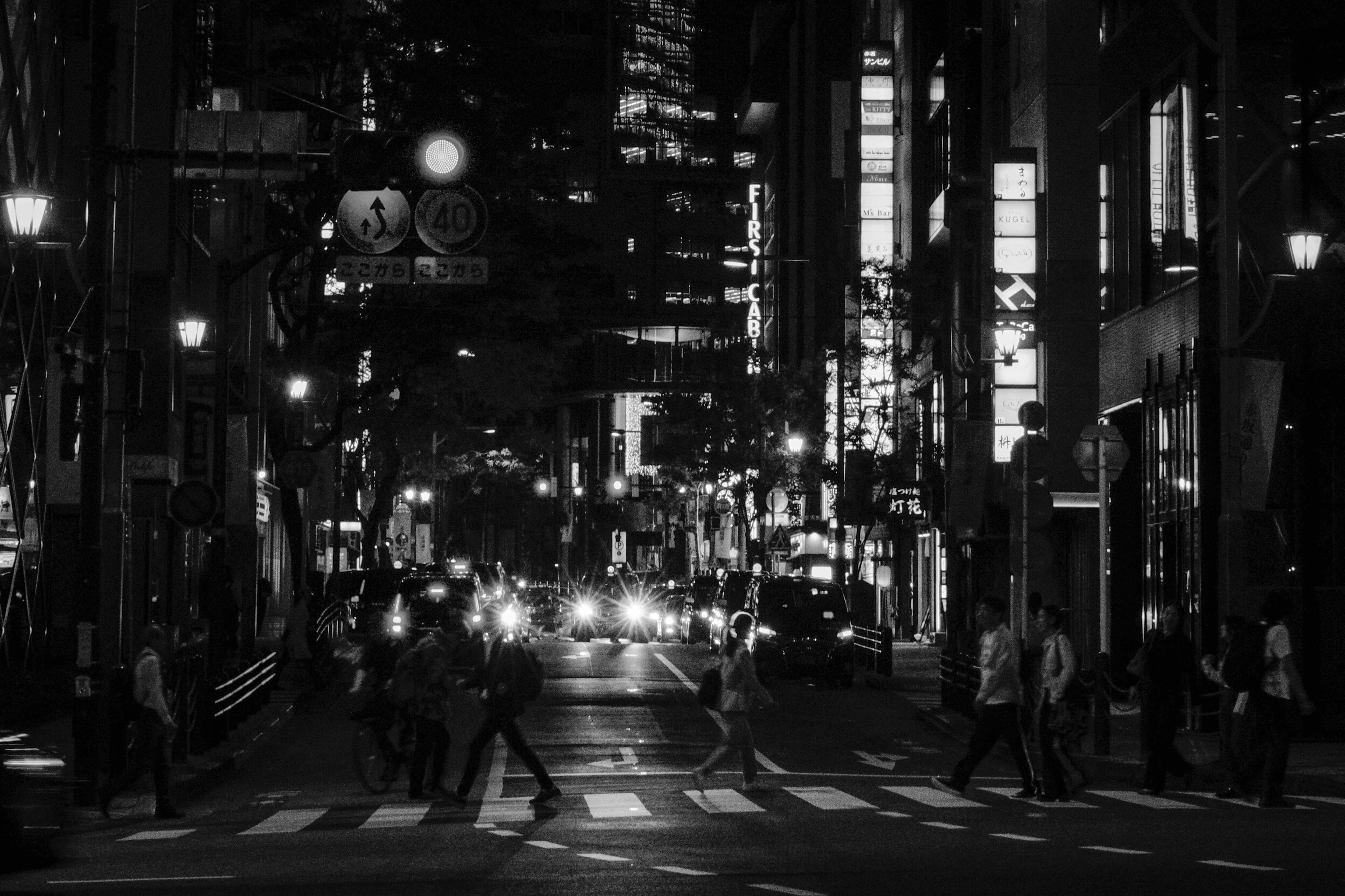 赤坂の夜景の街路を走る車の光がにじむ路地の風景