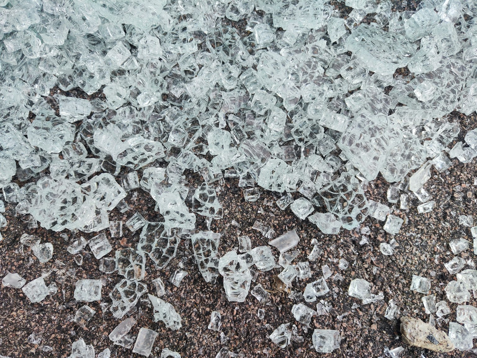 Zersplitterte Eisstücke, die über Sand verstreut sind, mit einzigartigen Mustern