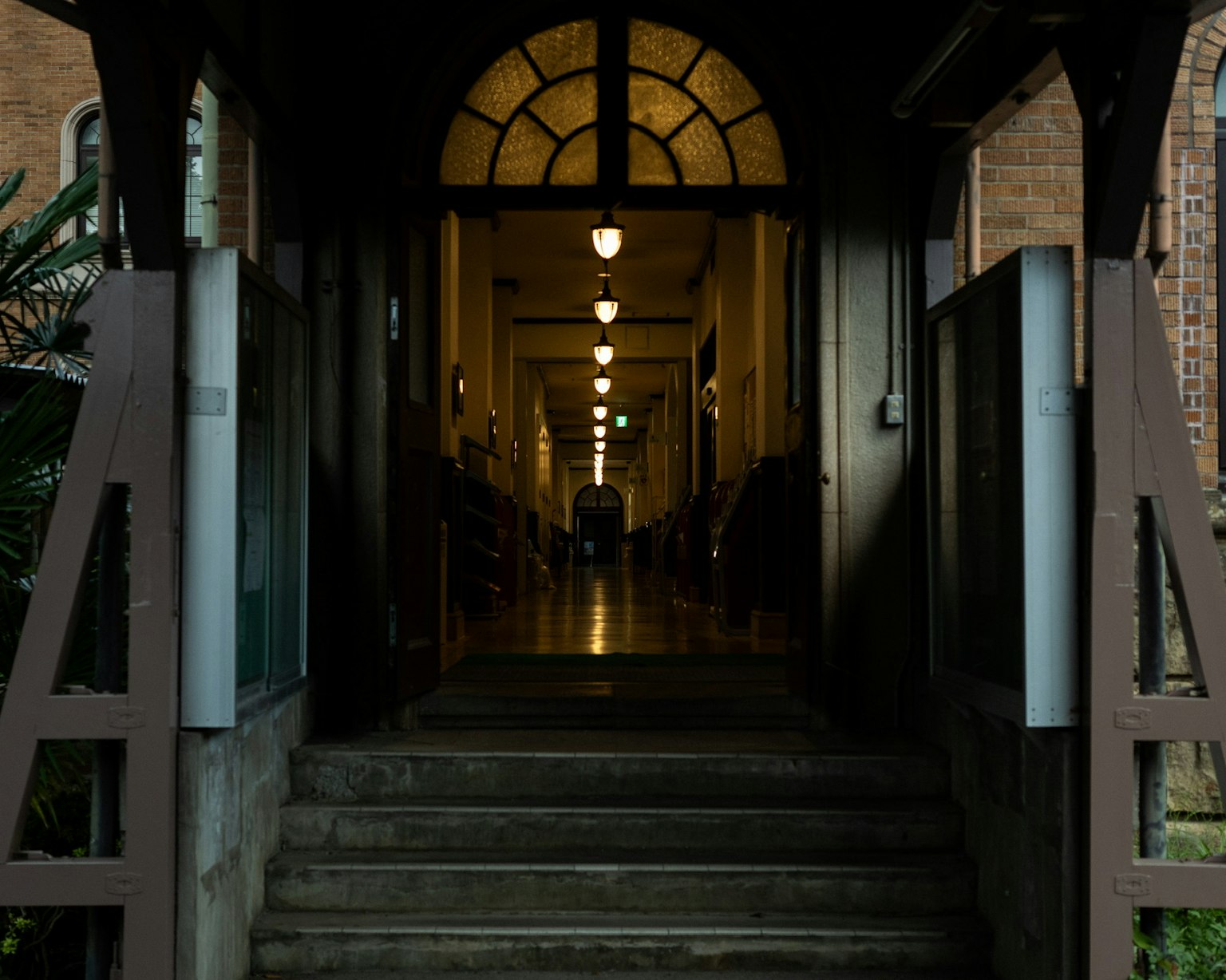 Vue d'un couloir depuis l'entrée d'un bâtiment avec un arc et des lumières alignées