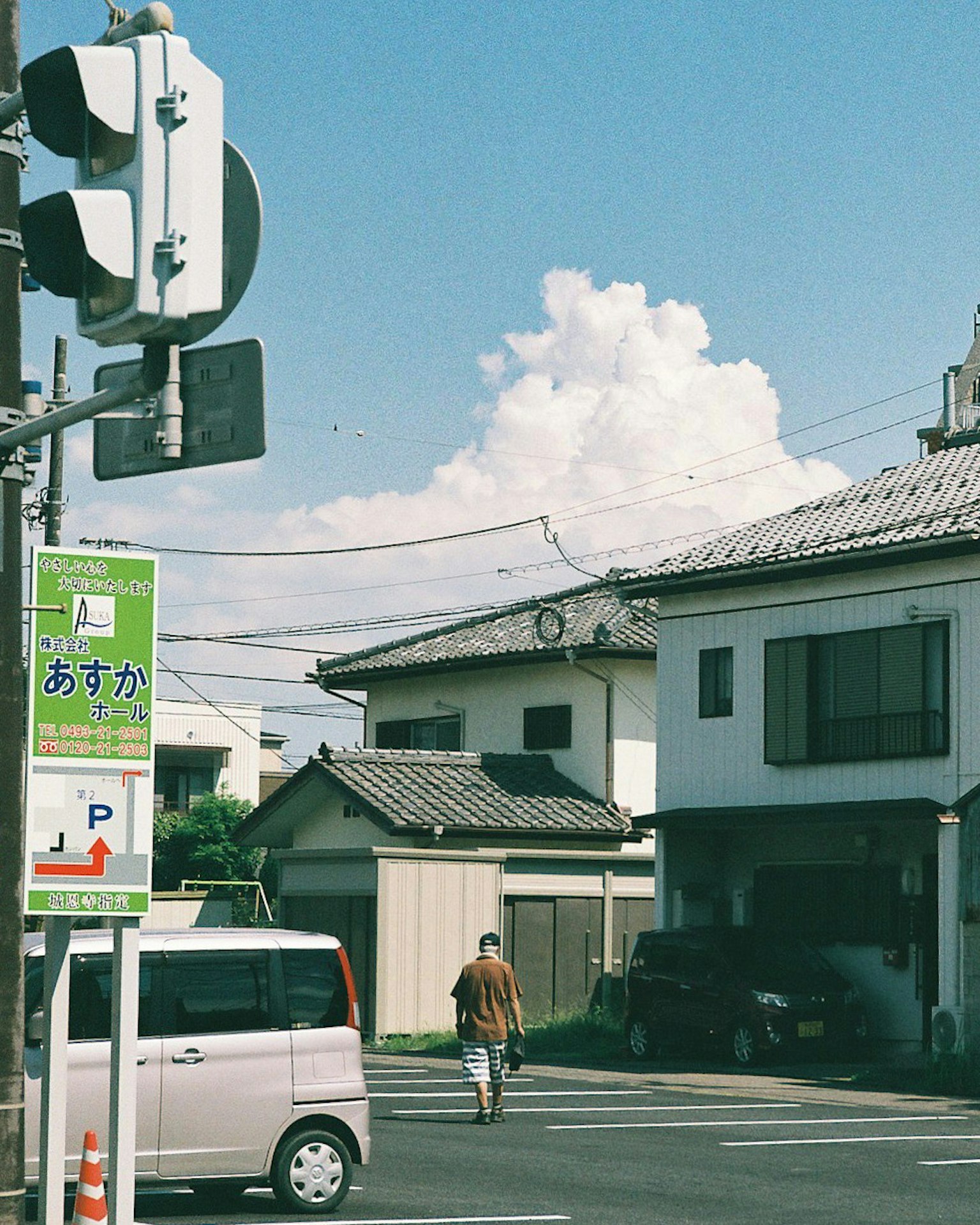 Una persona caminando en una zona residencial bajo un cielo azul