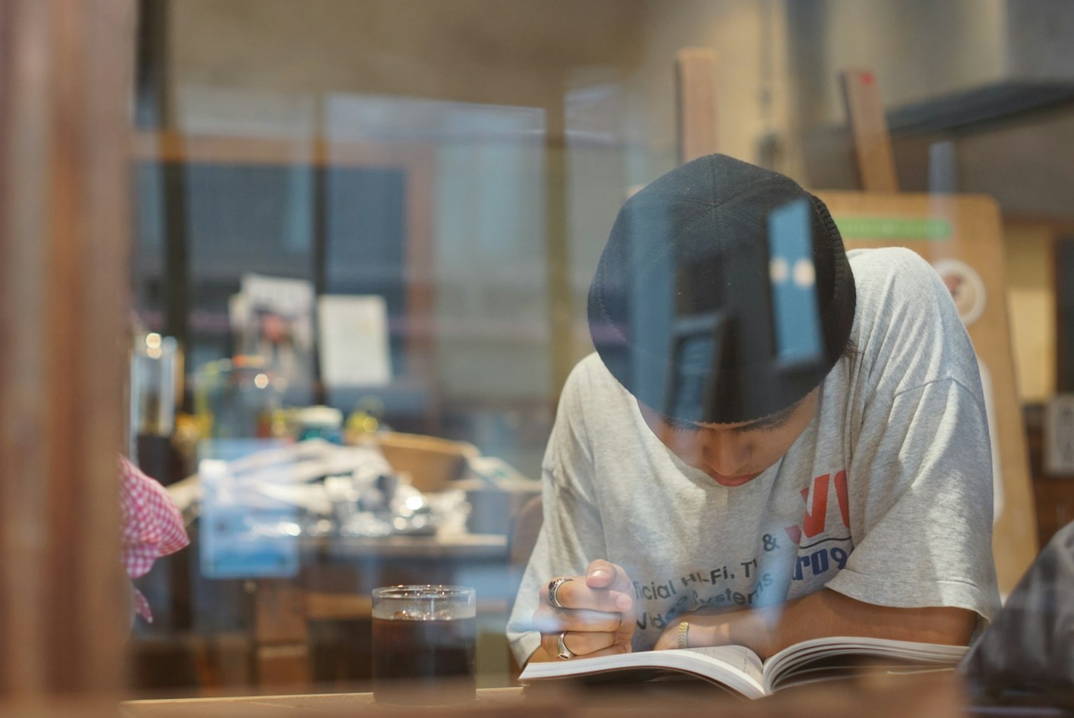 Persona che legge un libro attraverso una finestra È concentrato Vicino c'è un tavolo disordinato