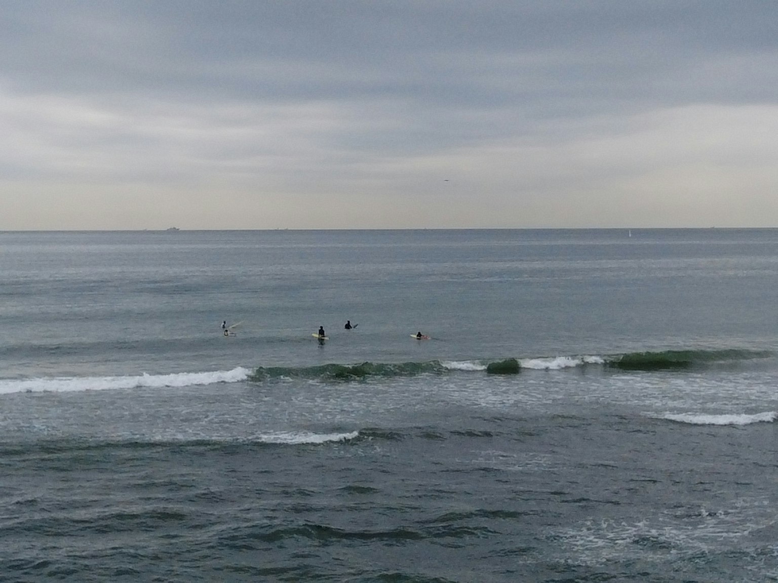 Surfer reiten auf Wellen in einem bewölkten Ozean
