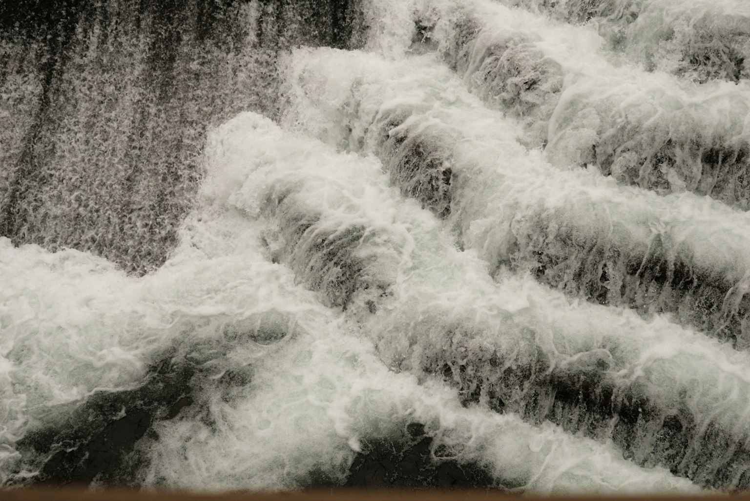 Onde bianche che scorrono su flussi d'acqua a gradini