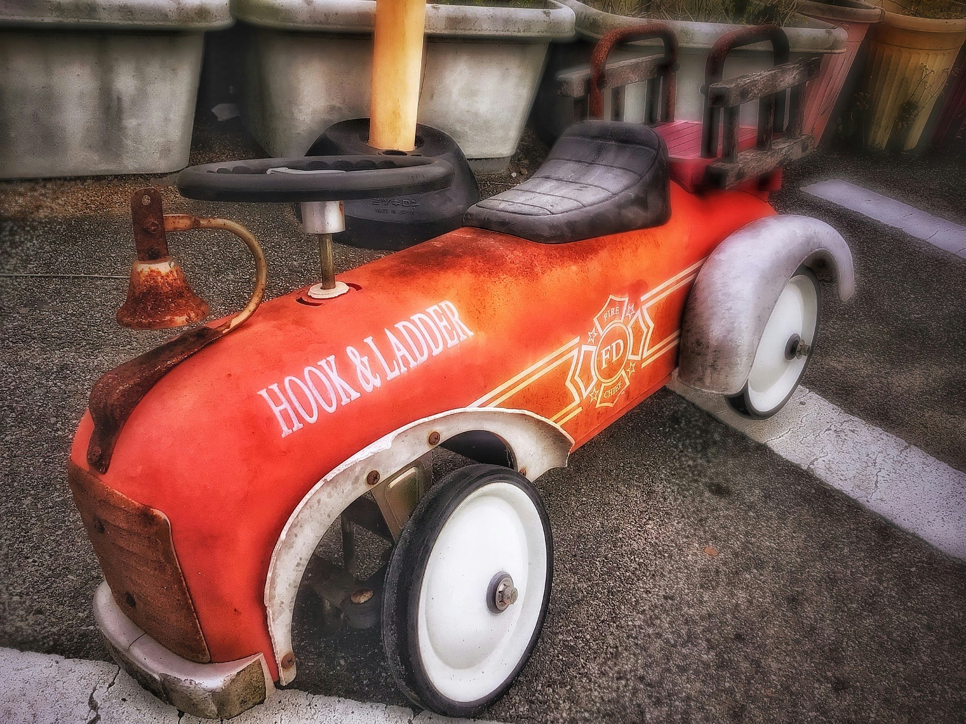 錆びた赤いレトロな子供用乗り物（壊れた車）