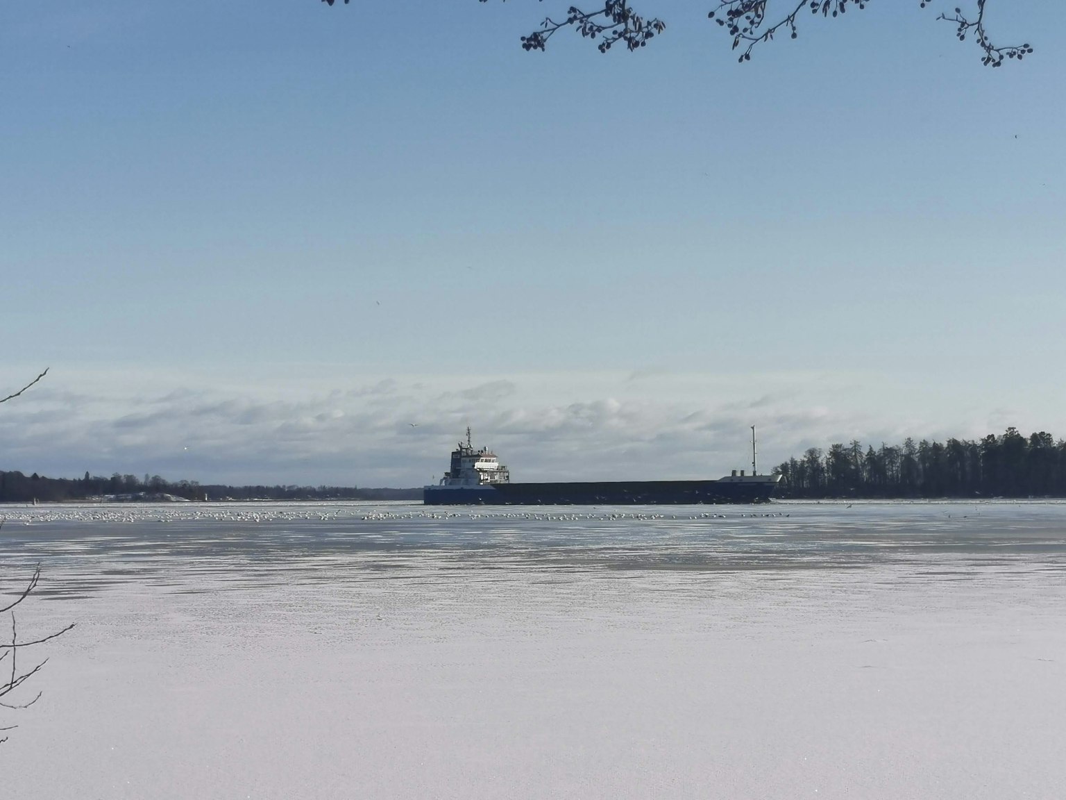 Un bateau naviguant sur une rivière gelée sous un ciel bleu clair