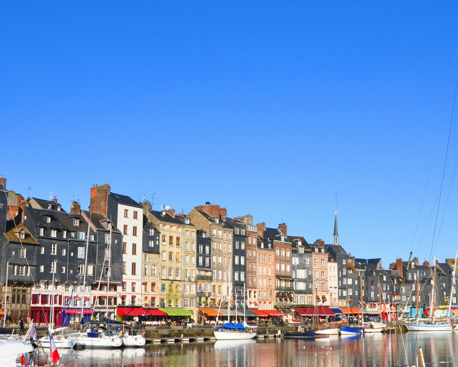 Port avec des bâtiments colorés et des bateaux sous un ciel bleu