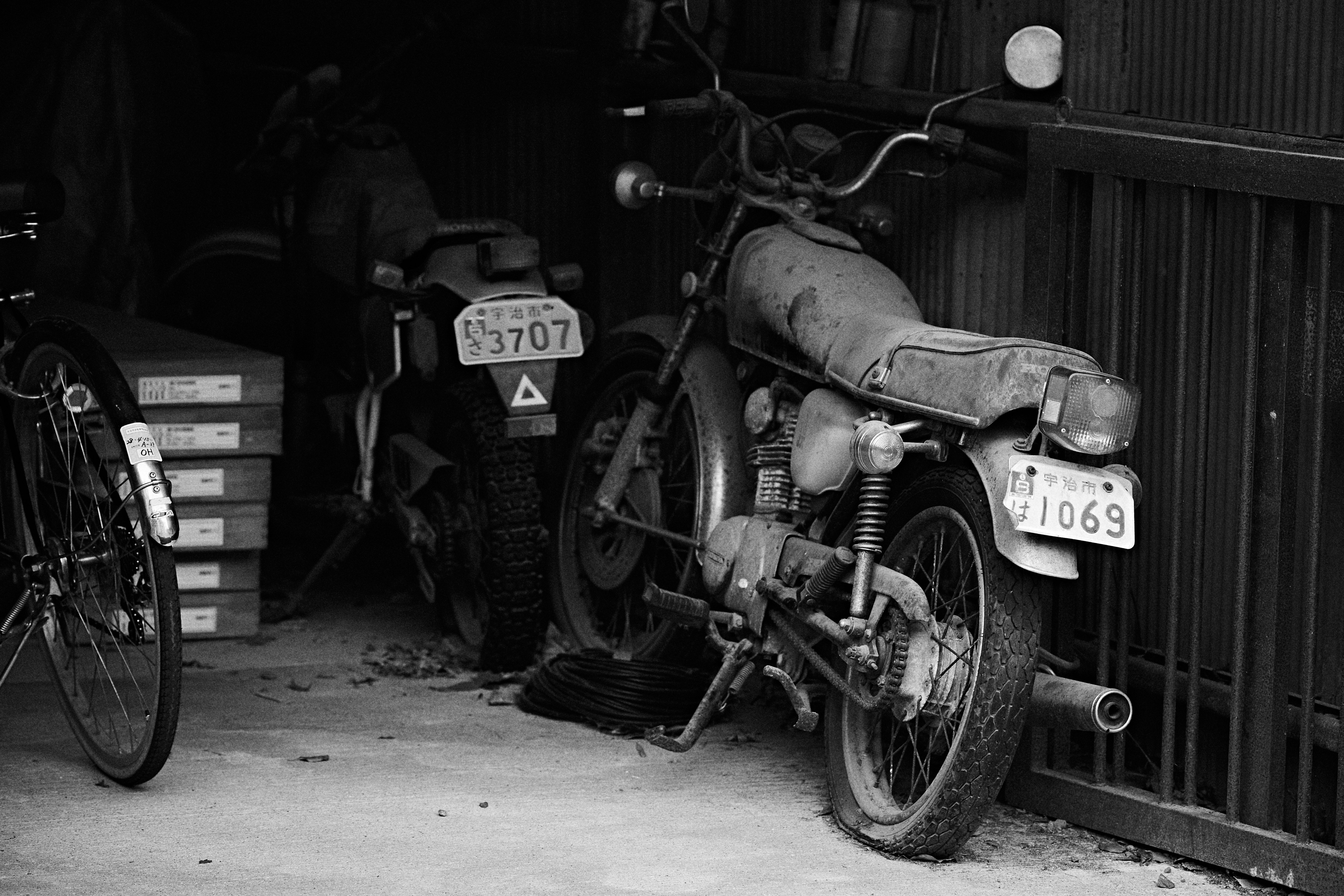 京都の路地に並ぶバイクと自転車のある軒先
