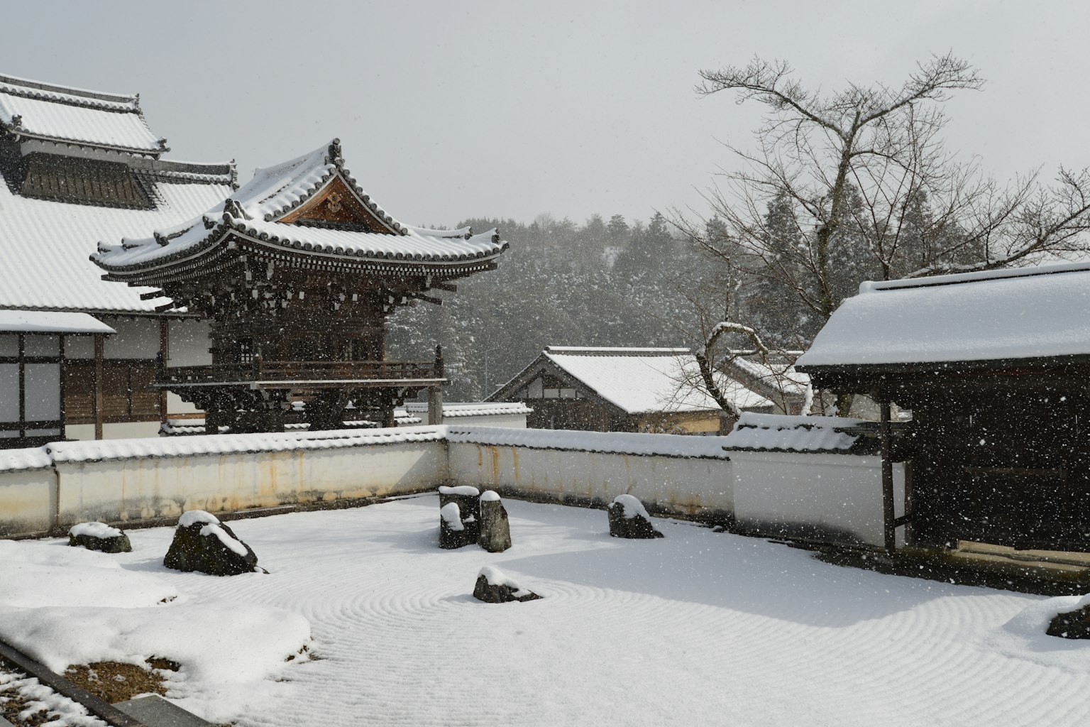 Edificios tradicionales japoneses y jardín cubiertos de nieve
