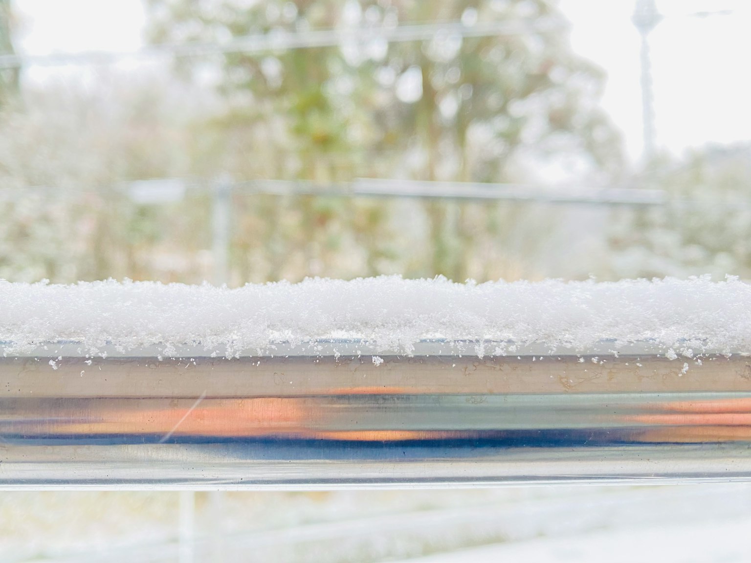 窗台上覆蓋著雪，背景模糊的樹木