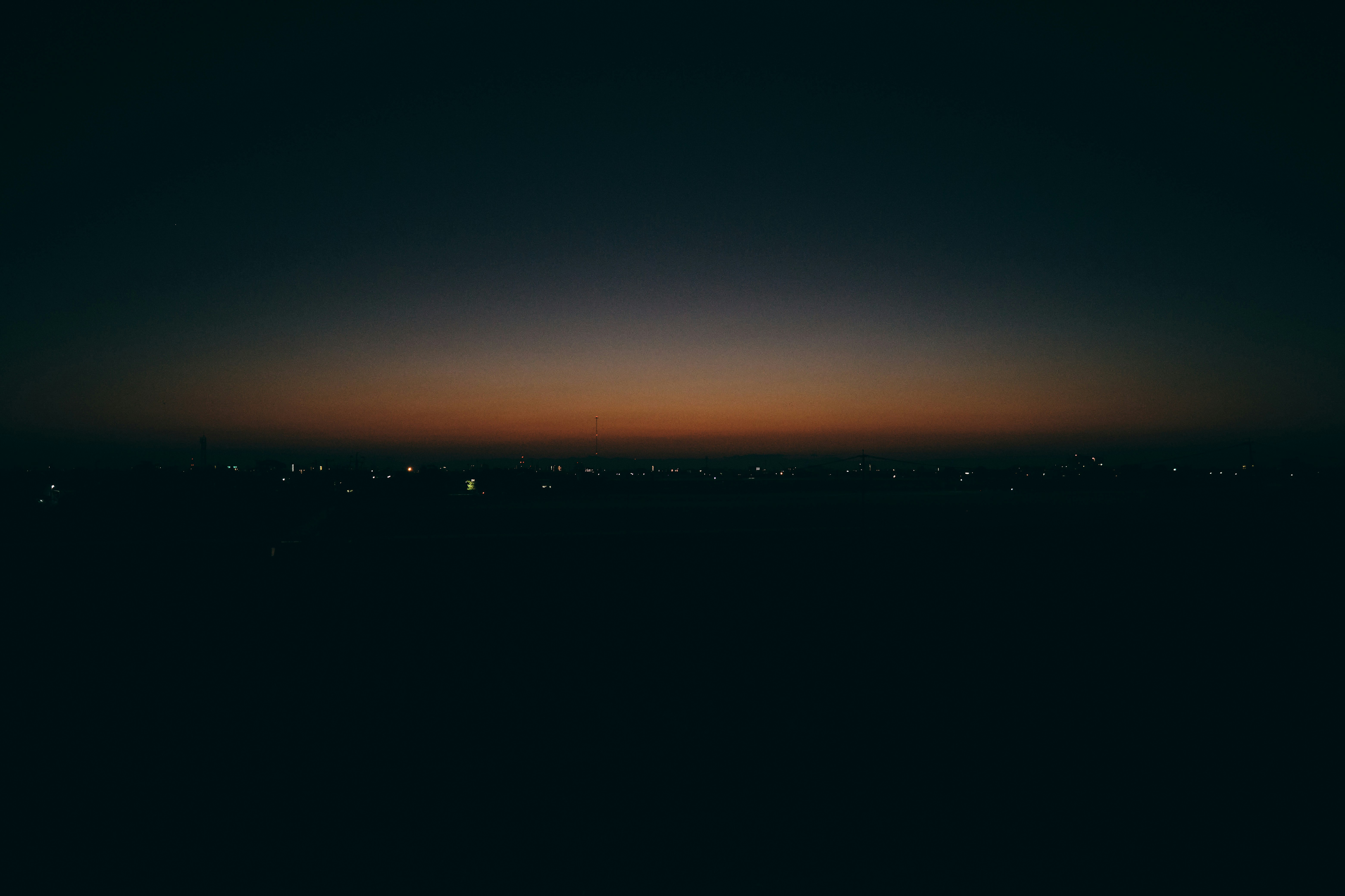 luci della città lontane sotto un cielo al tramonto