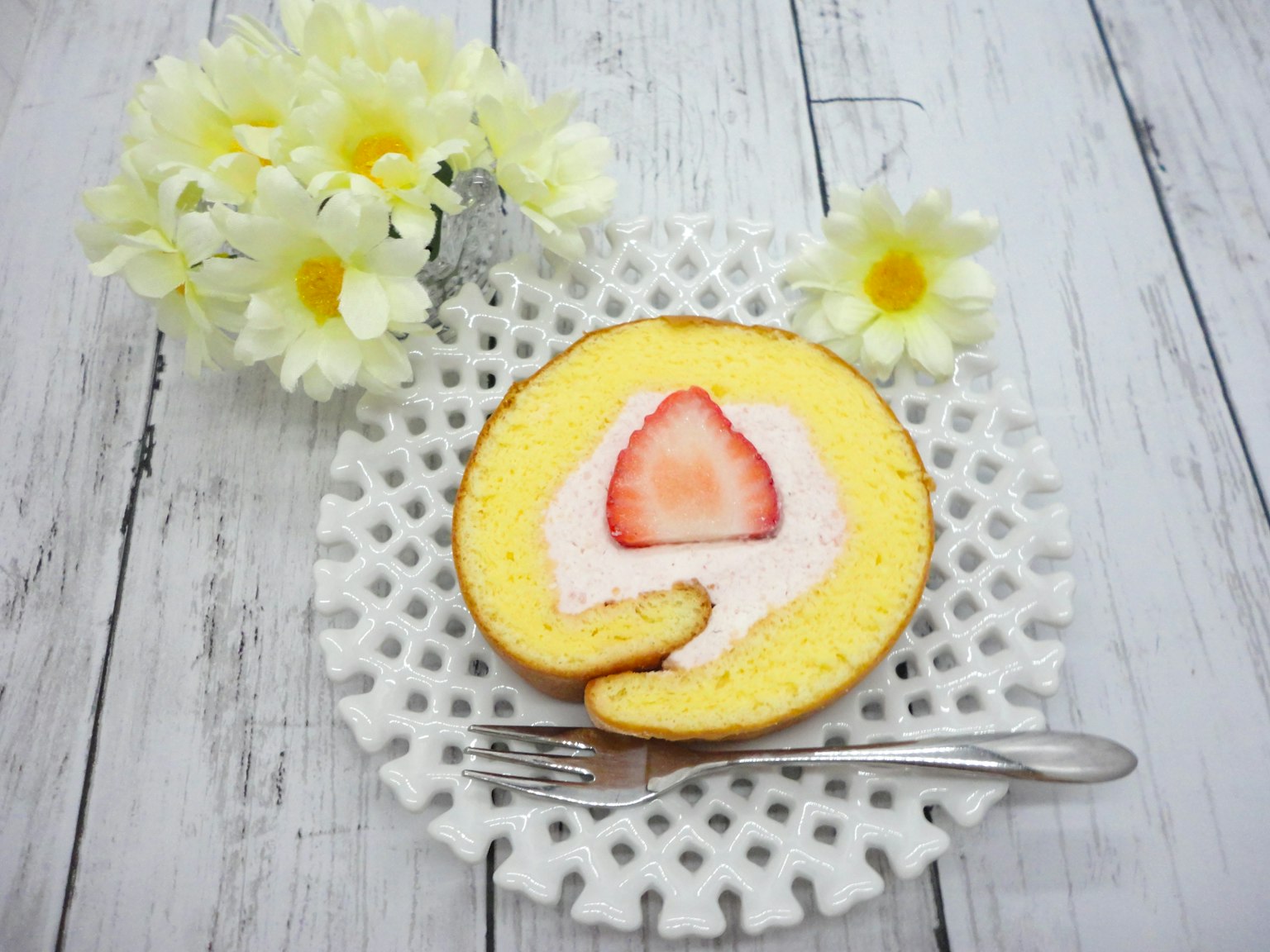 Scheibe von gelbem Biskuitkuchen mit Erdbeere auf einem dekorativen Teller