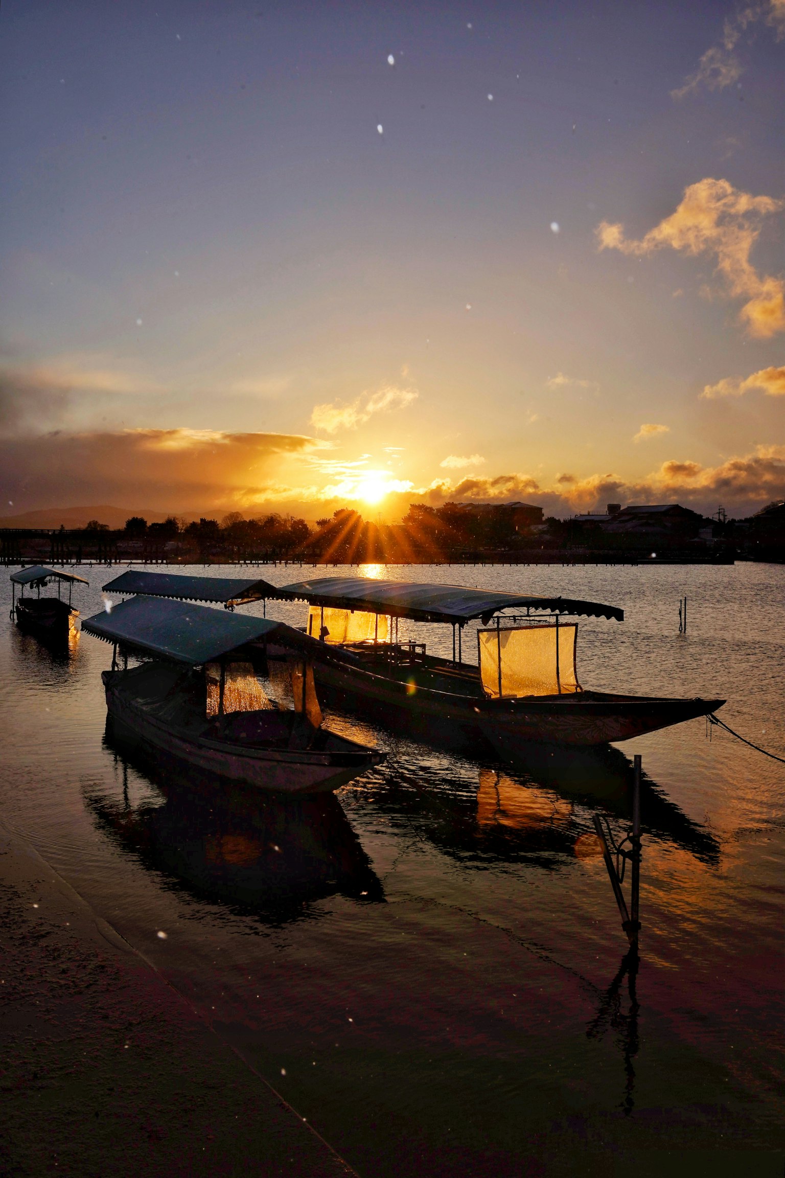 Barche sull'acqua che riflettono il tramonto