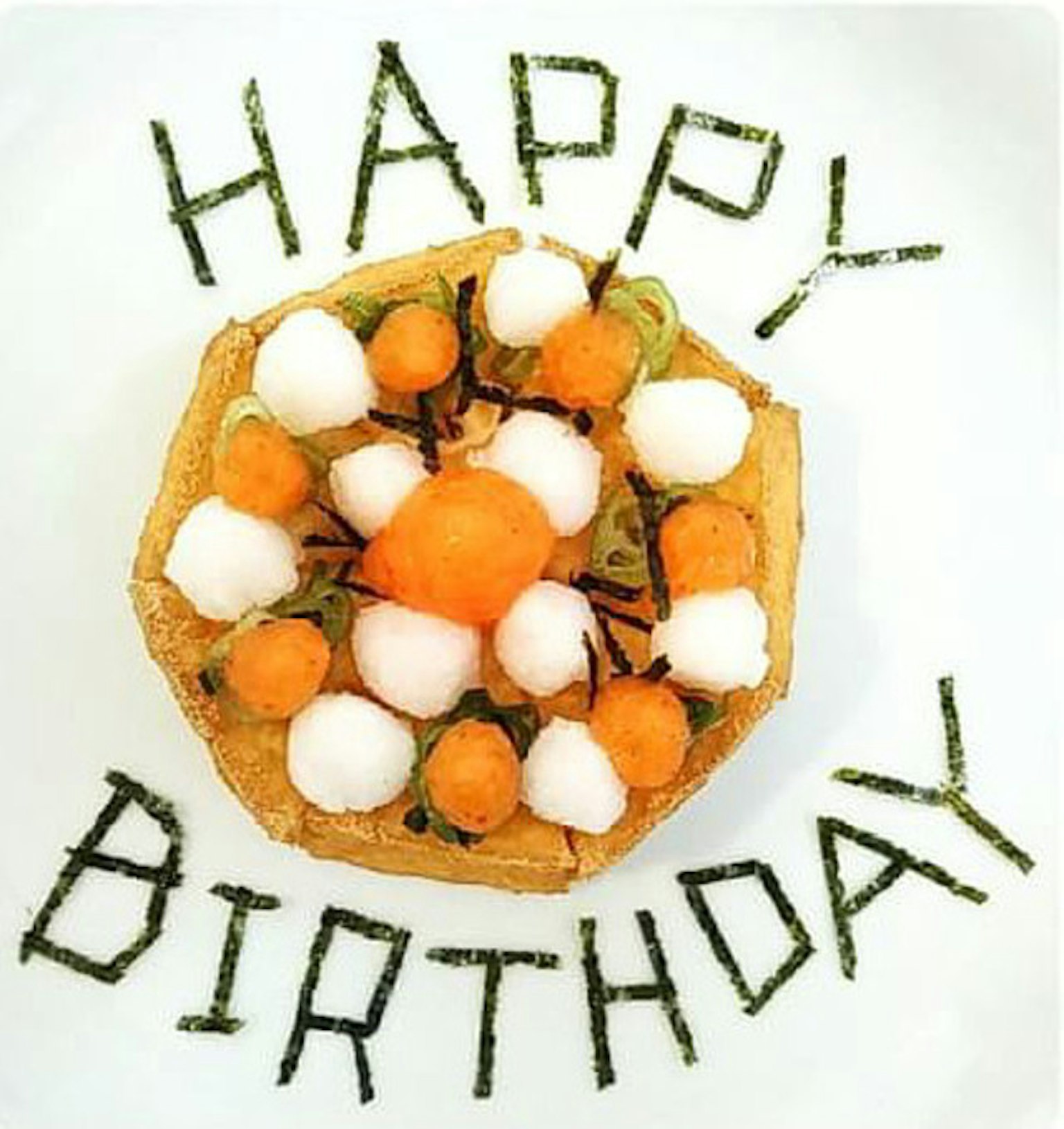 과일로 장식된 생일 케이크가 있는 접시에 생일 축하라는 글자가 적혀 있다