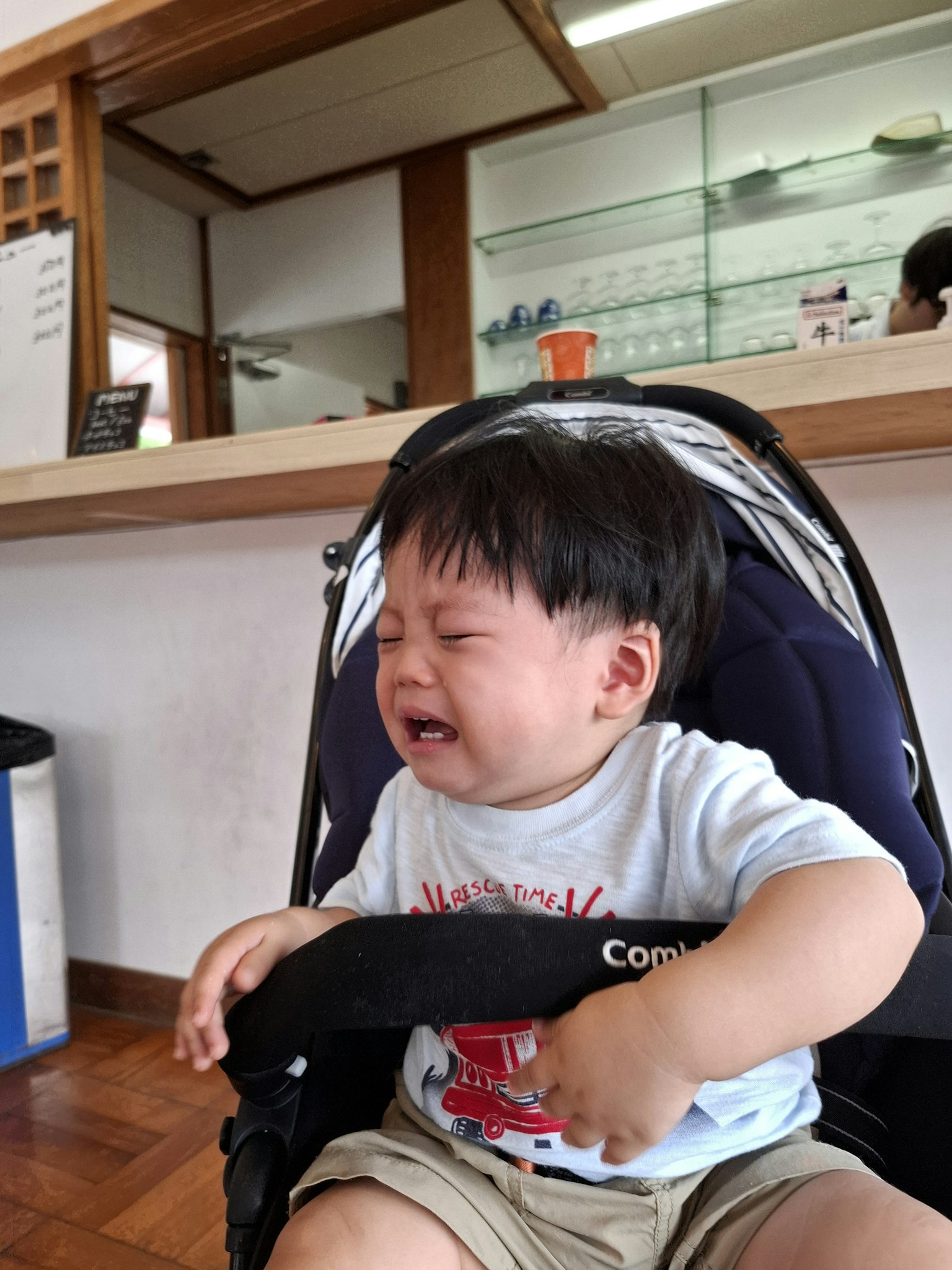 Un bambino che piange seduto in un passeggino