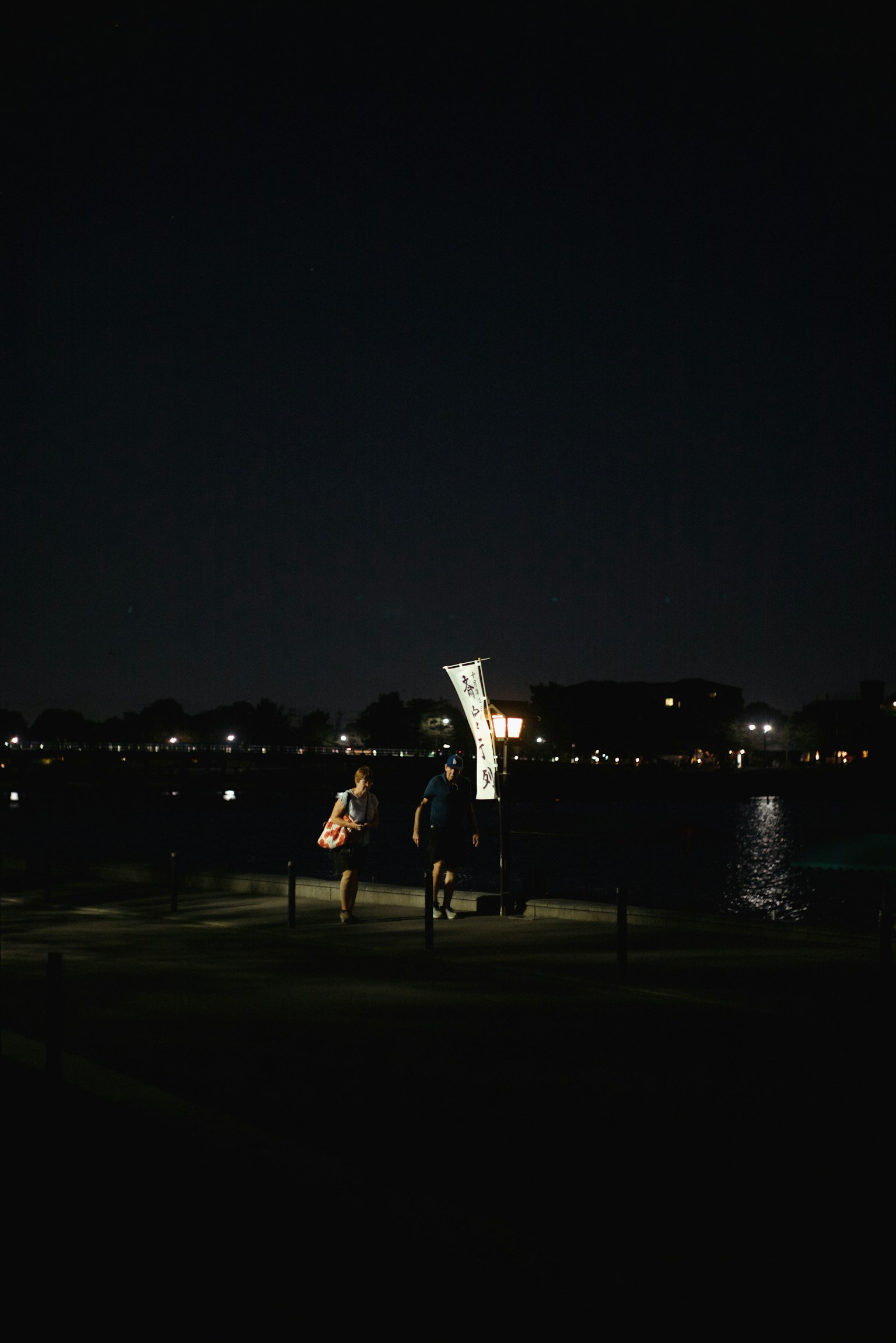 Menschen in einem Park bei Nacht mit beleuchtetem Skulptur