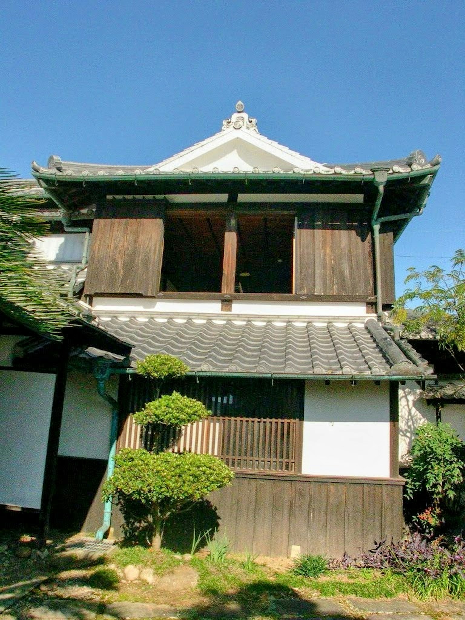 傳統日本建築外觀，屋頂覆蓋瓦片，木製窗戶