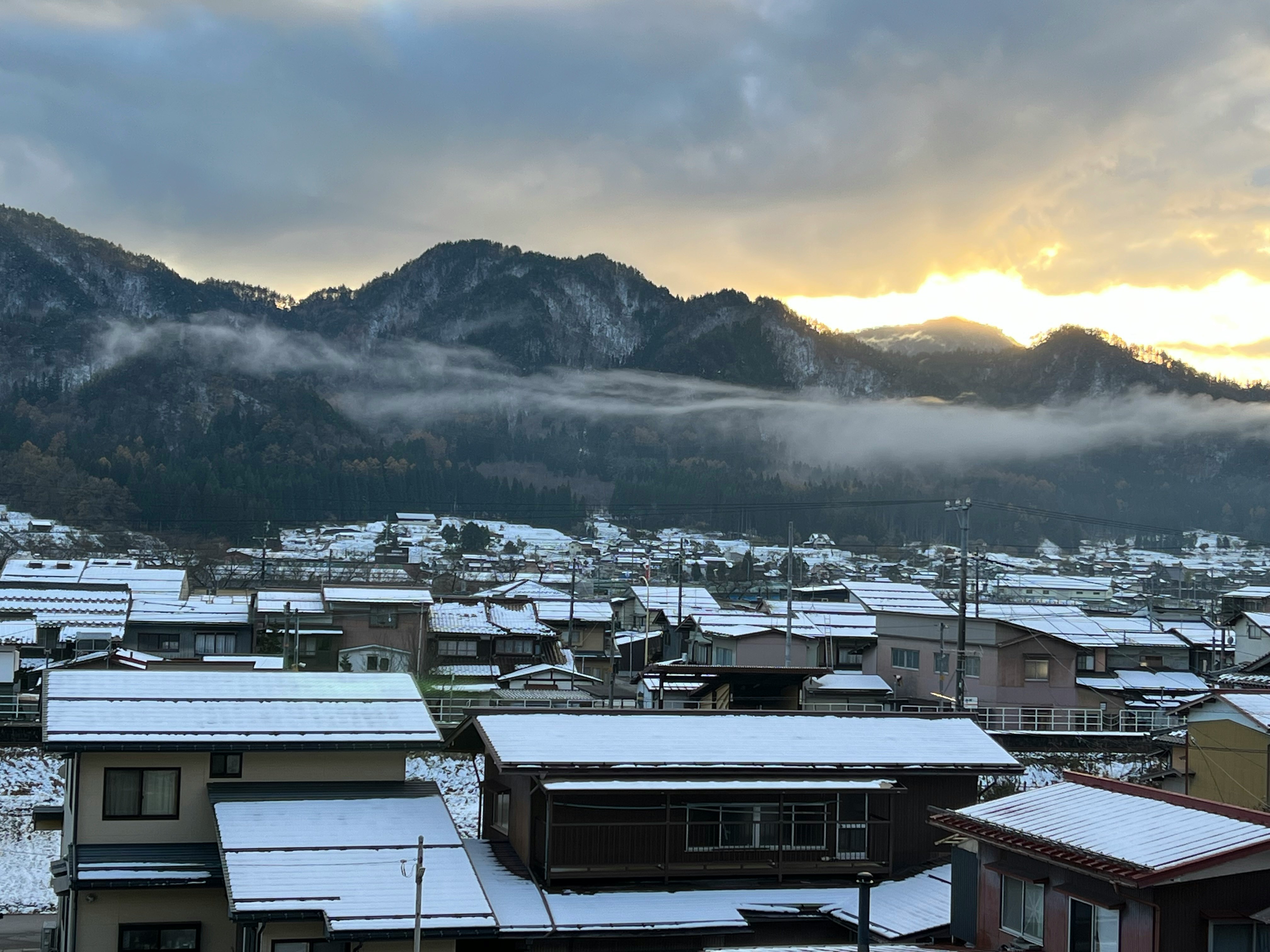 山间村庄的积雪屋顶与日出薄雾