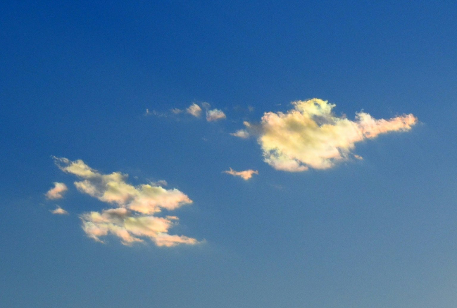 Bunte Wolken, die in einem klaren blauen Himmel schweben