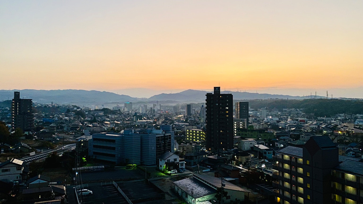 Vue panoramique d'une ville au crépuscule avec des bâtiments et des montagnes