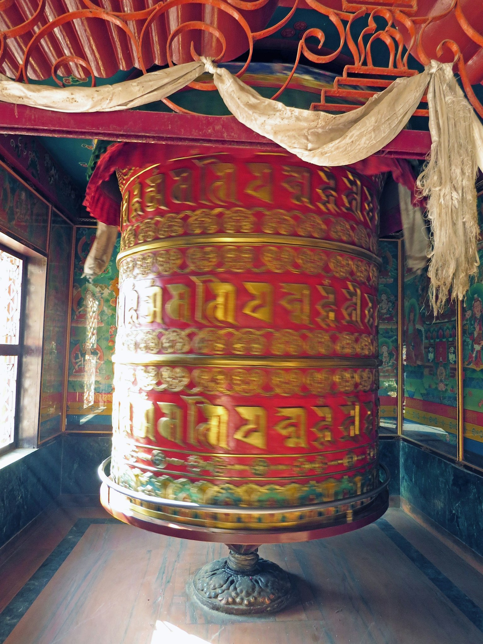 寺廟內部有一個大型佛教祈禱輪和生動的牆面裝飾