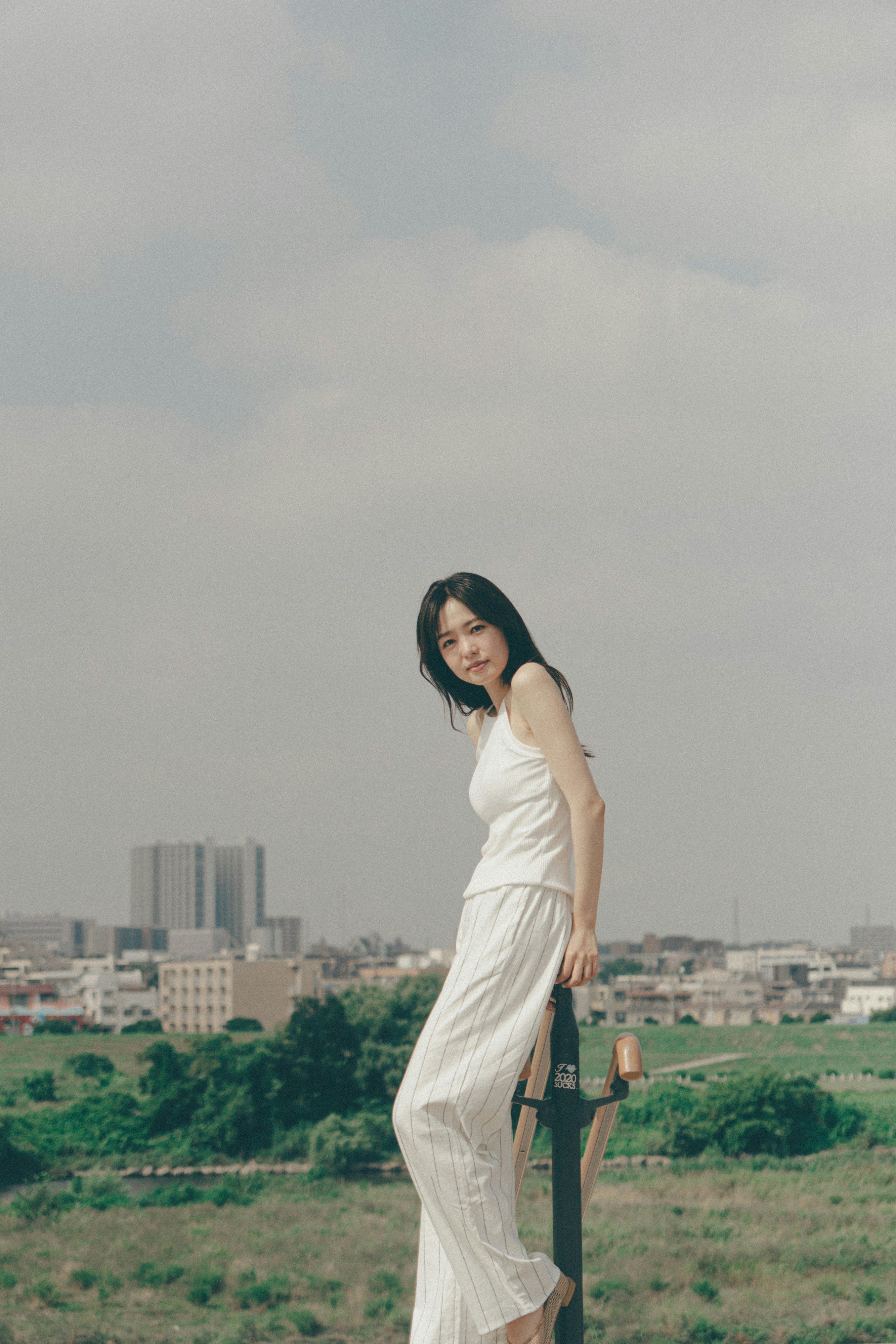 草地の丘で手すりにもたれる女性のポートレート
