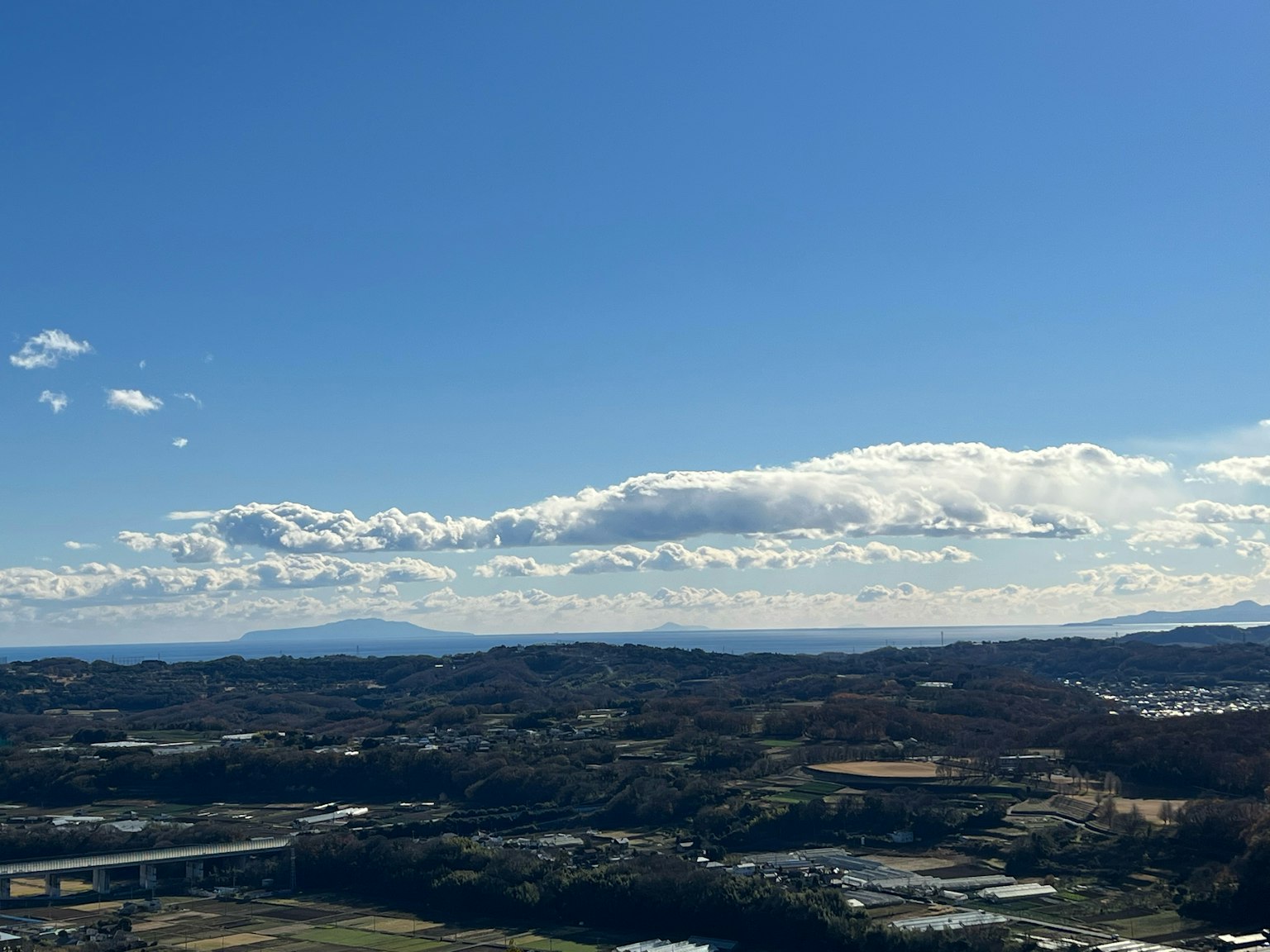 Paysage avec ciel bleu et nuages sur des collines et des champs