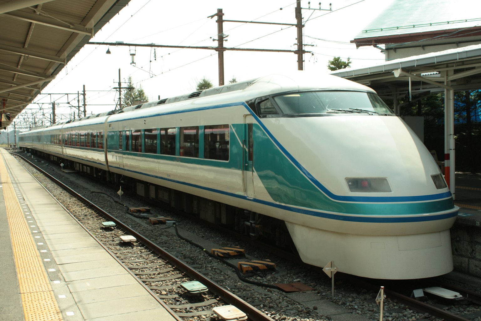 Treno espresso con strisce blu parcheggiato alla stazione