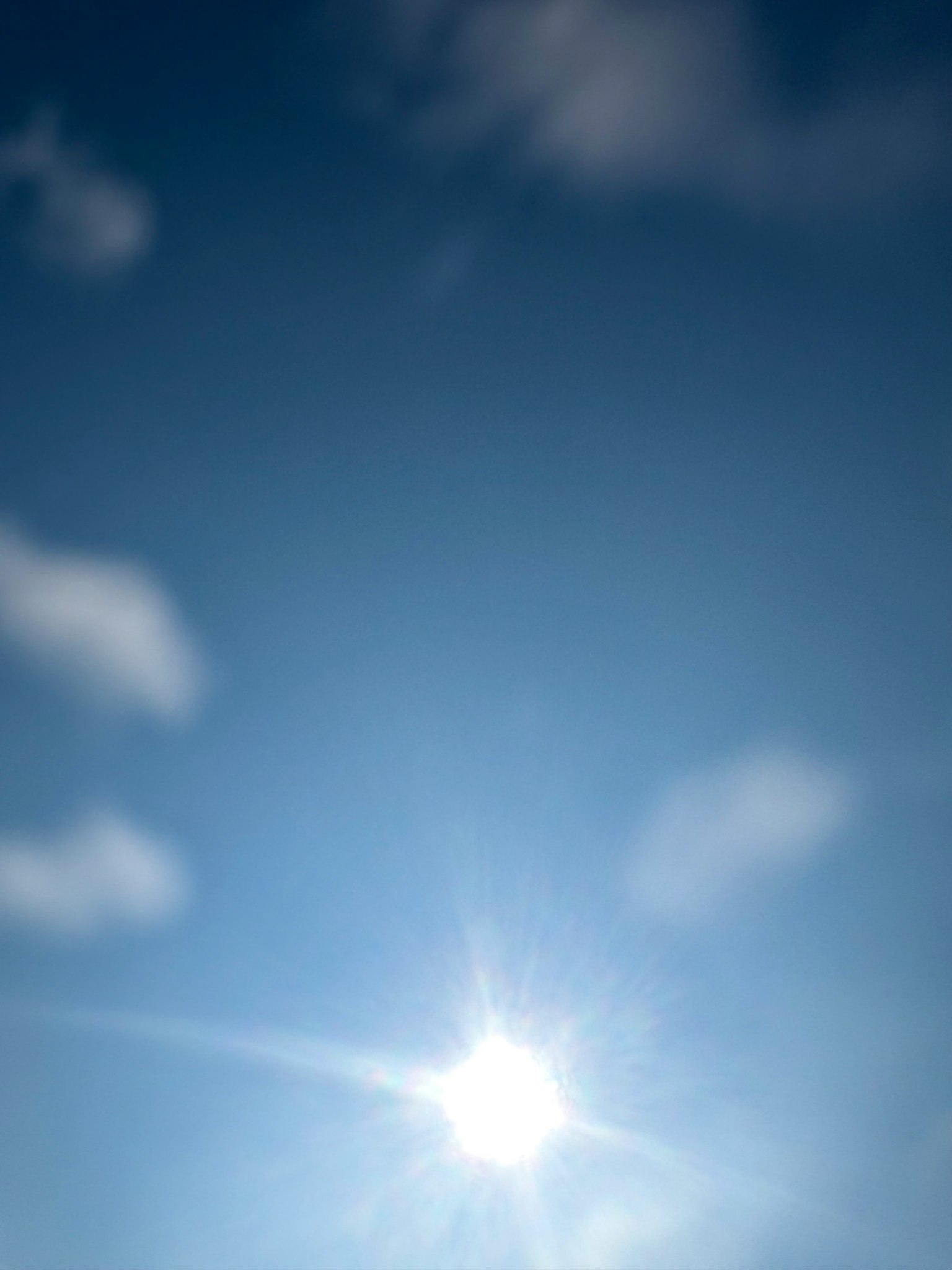 Soleil brillant dans un ciel bleu avec des nuages blancs